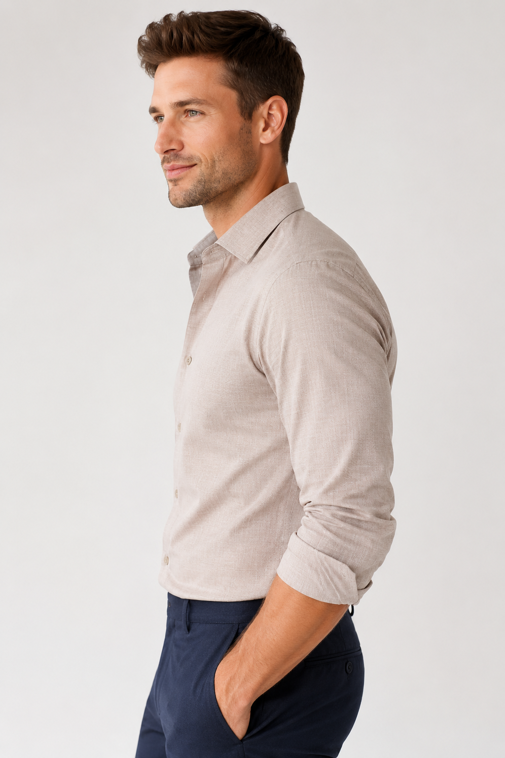 Man wearing a light gray long-sleeve shirt and navy pants on a white background