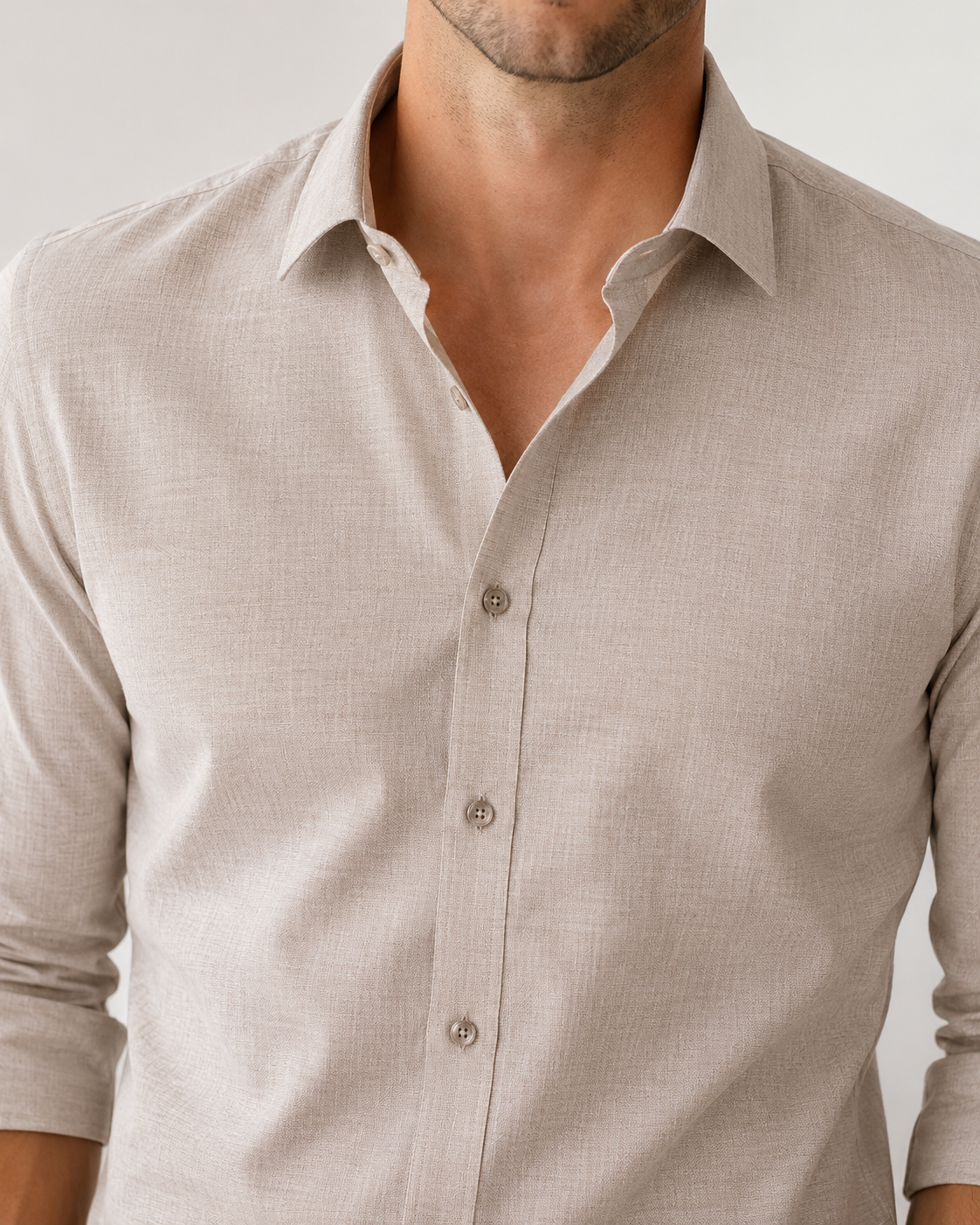 Man wearing a beige button-up shirt against a plain background