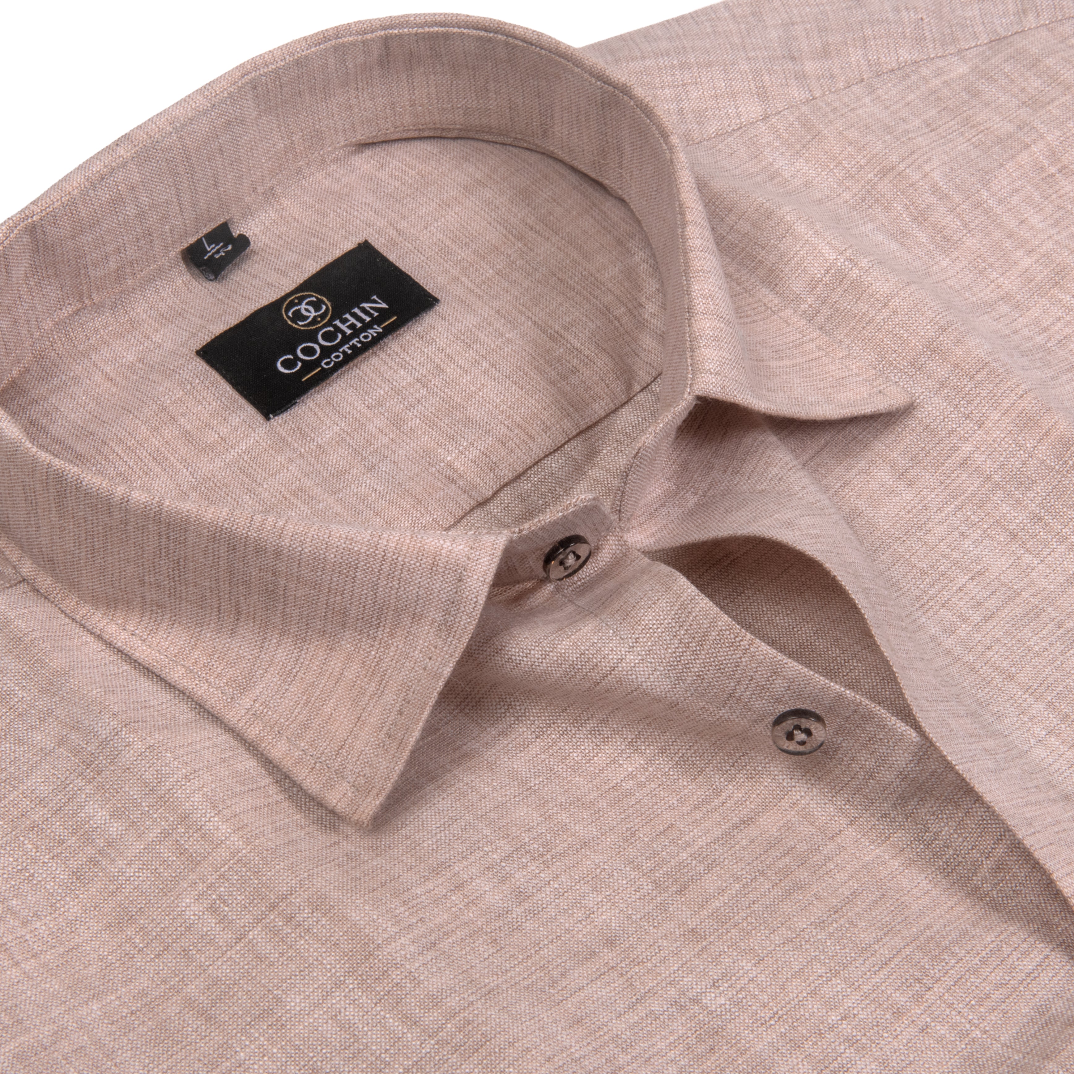 Close-up of a light beige linen shirt collar with a black Cochin Couture label, showing the textured fabric and button details.