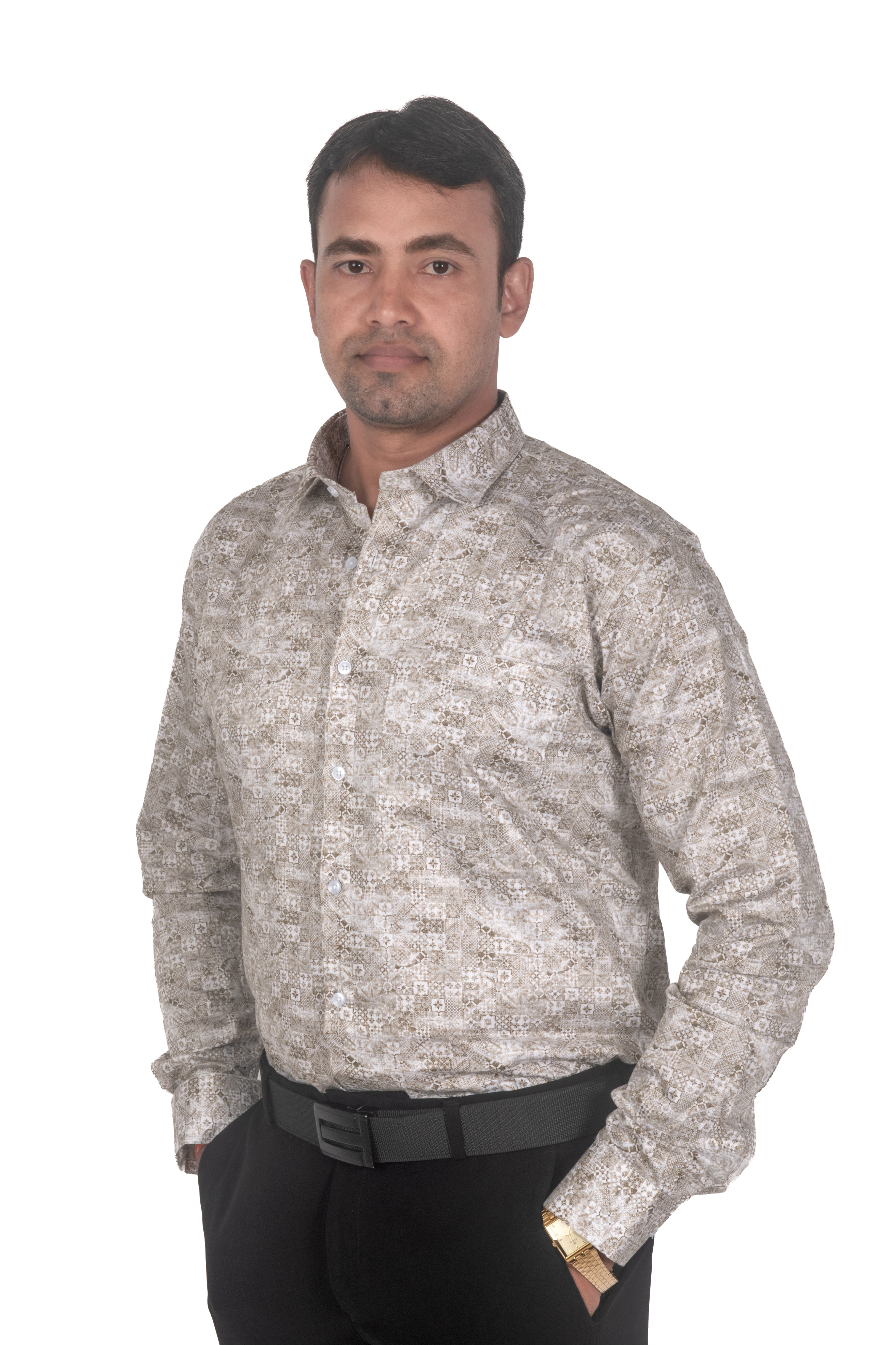 A man wearing a long-sleeve button-up shirt with a beige and gray floral pattern, paired with black trousers and a black belt, standing against a plain white background.