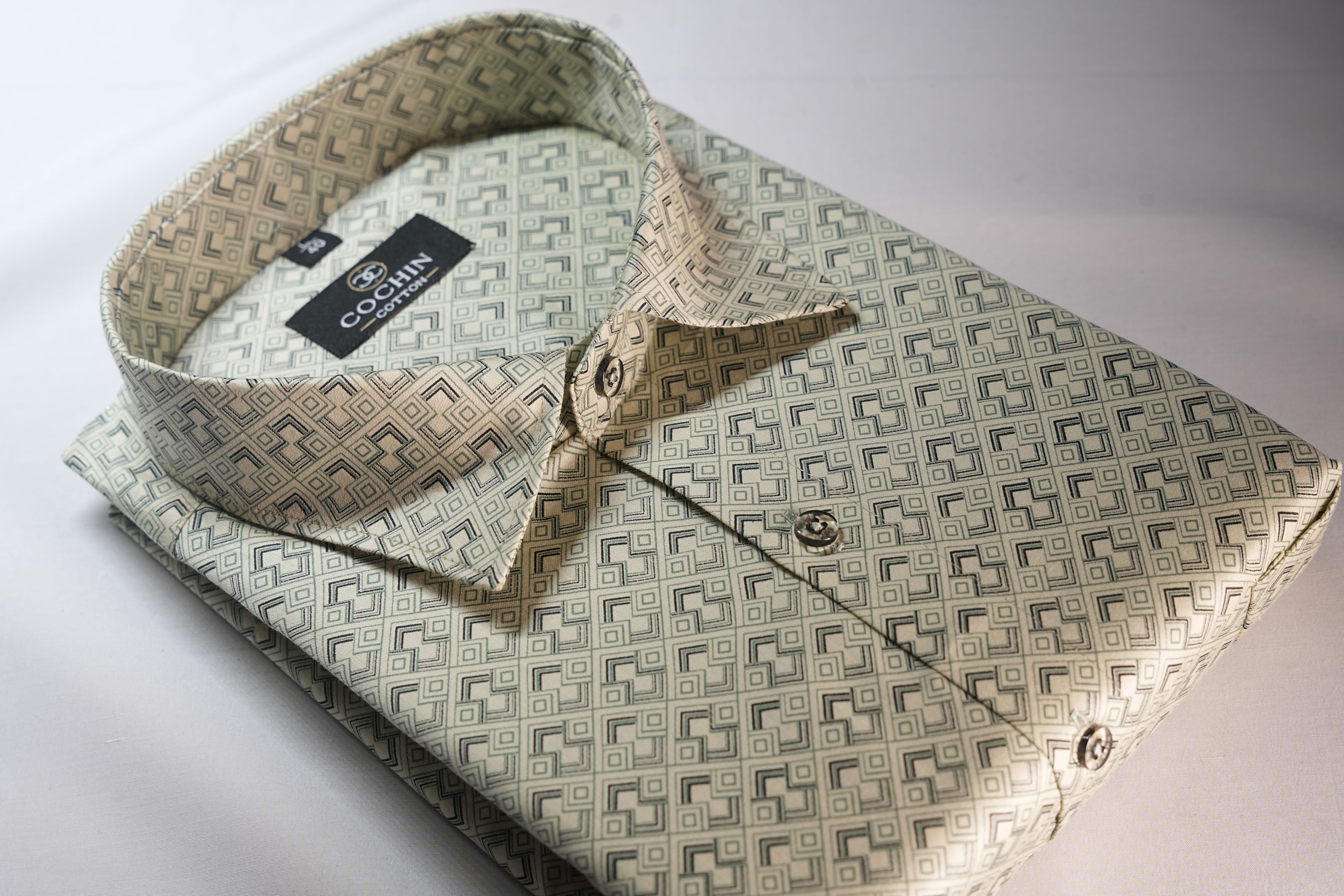 Folded shirt with geometric pattern and Coach label on a white background