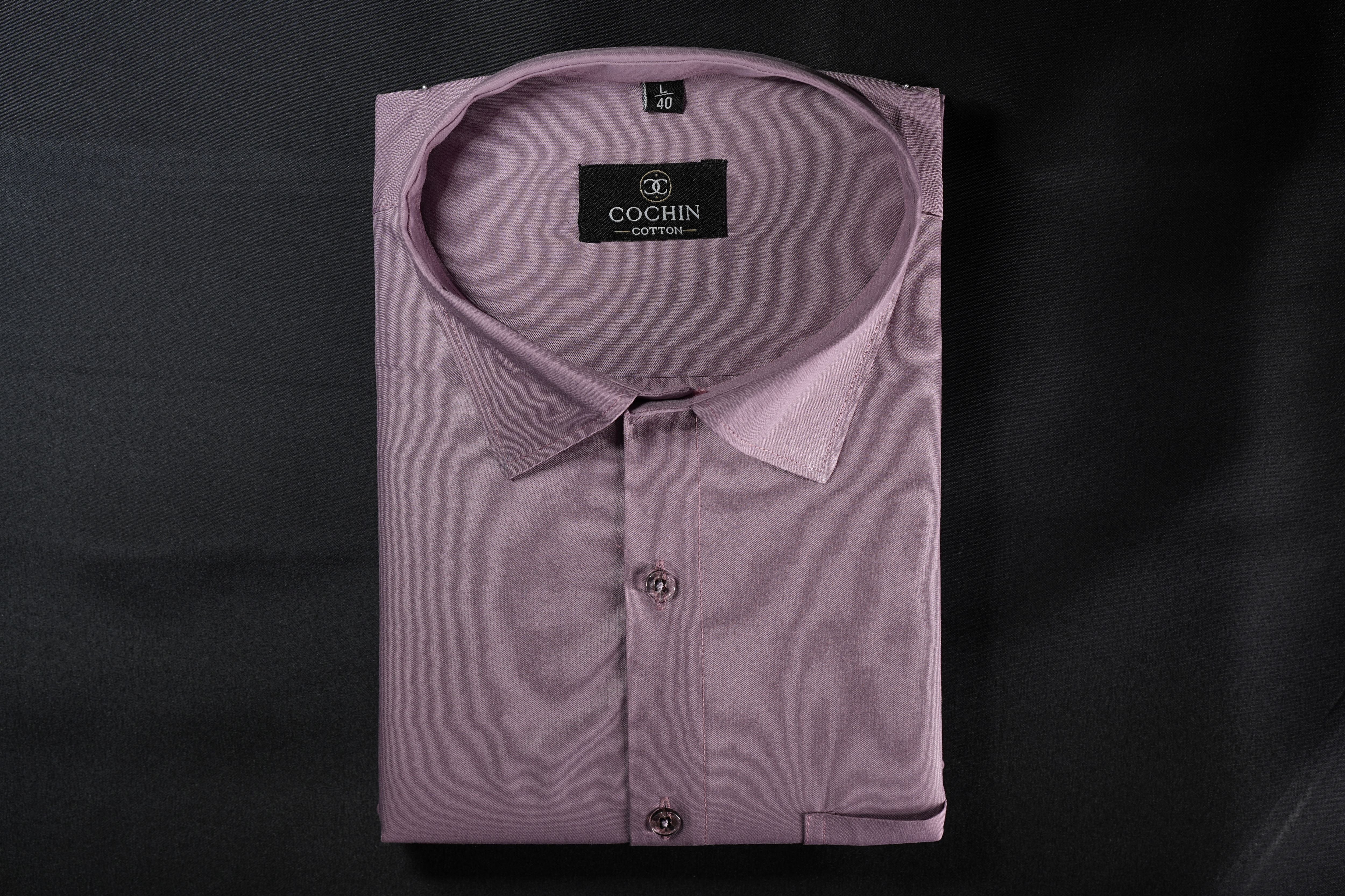A folded light purple Cochin cotton dress shirt with a pointed collar and button-down front, displayed on a dark background.