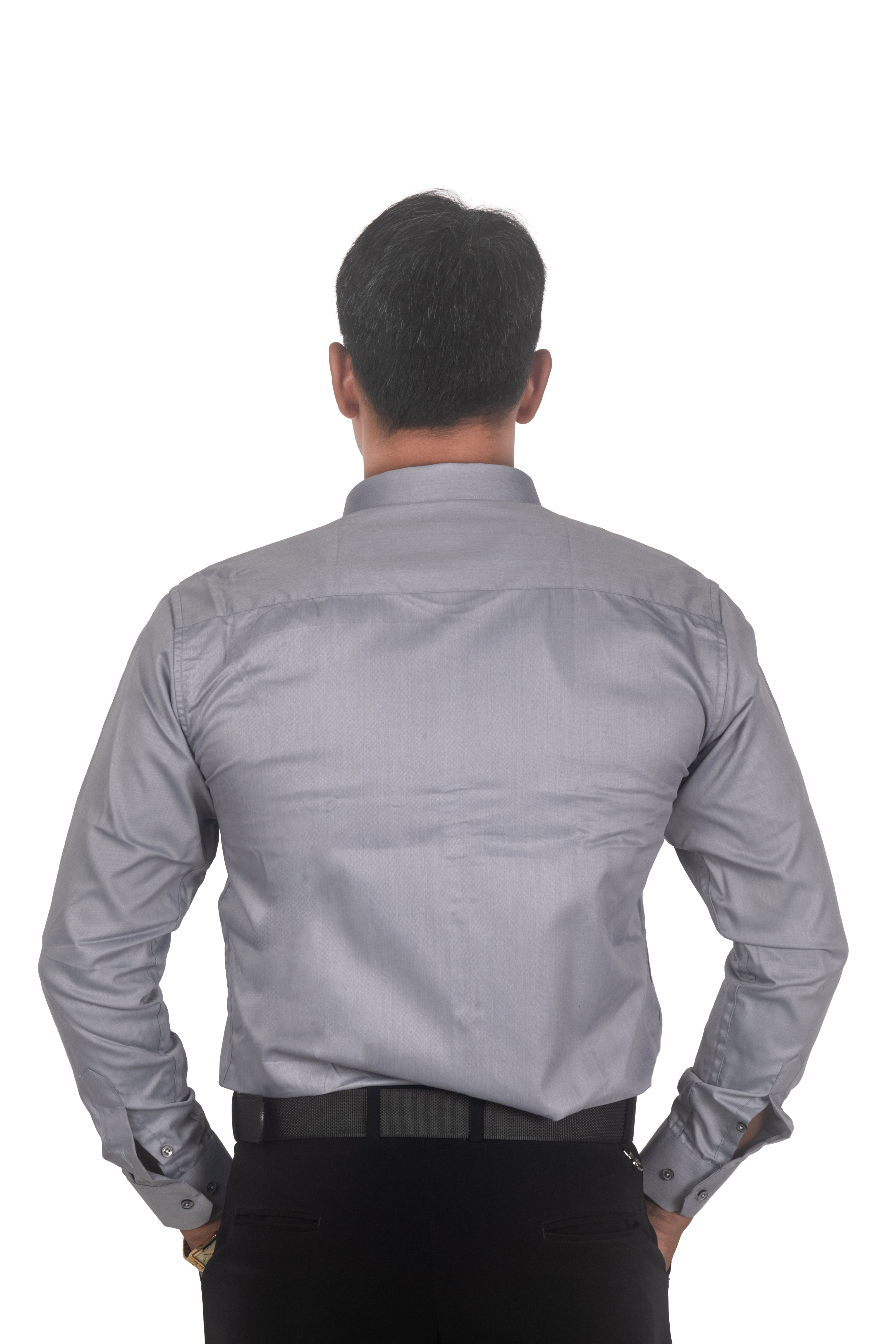 A man viewed from behind wearing a light gray long-sleeve dress shirt and black trousers, standing against a plain white background.