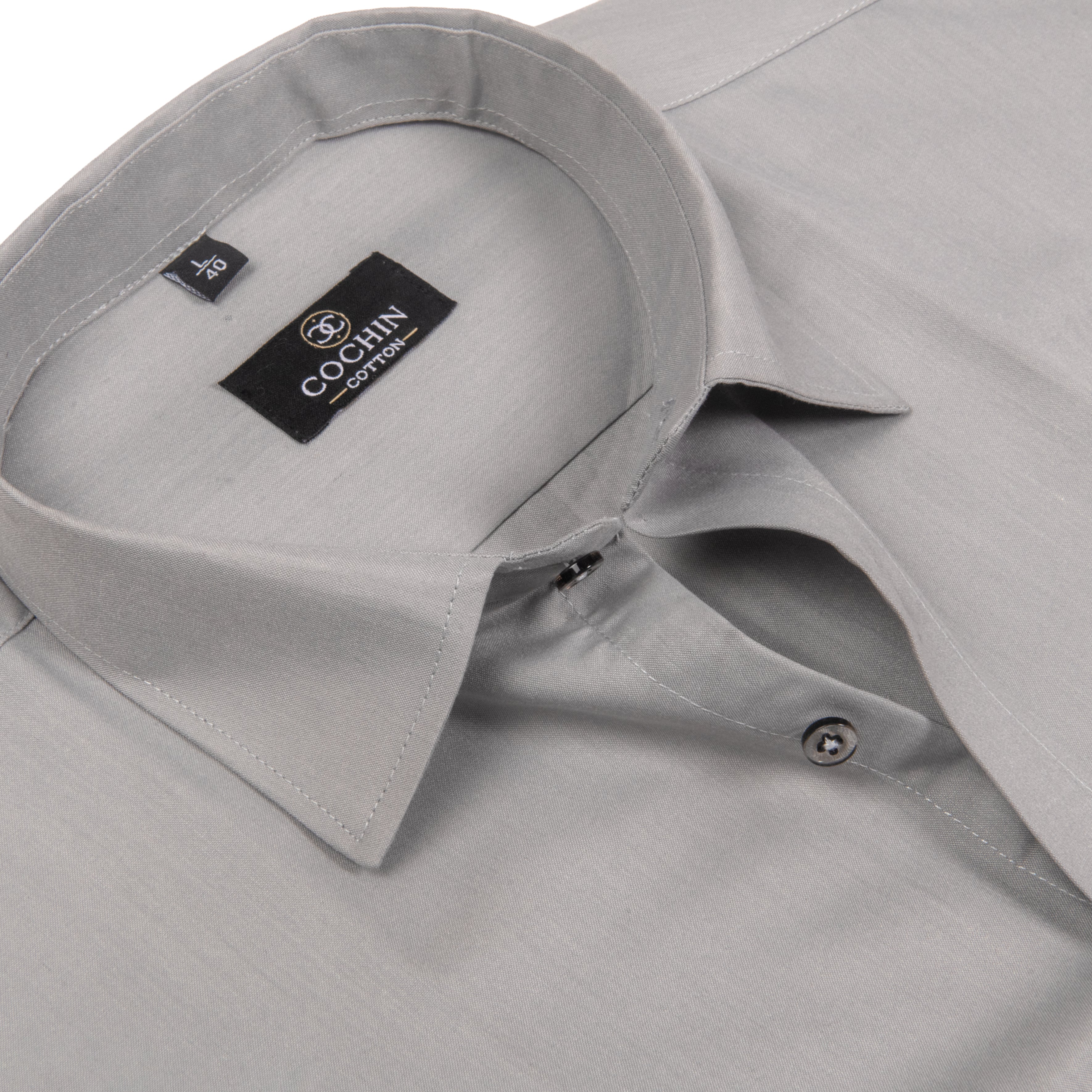 Close-up of a light gray long-sleeve dress shirt showing the collar, inner neck label, and button placket. The brand label reads COCHIN COTTON.