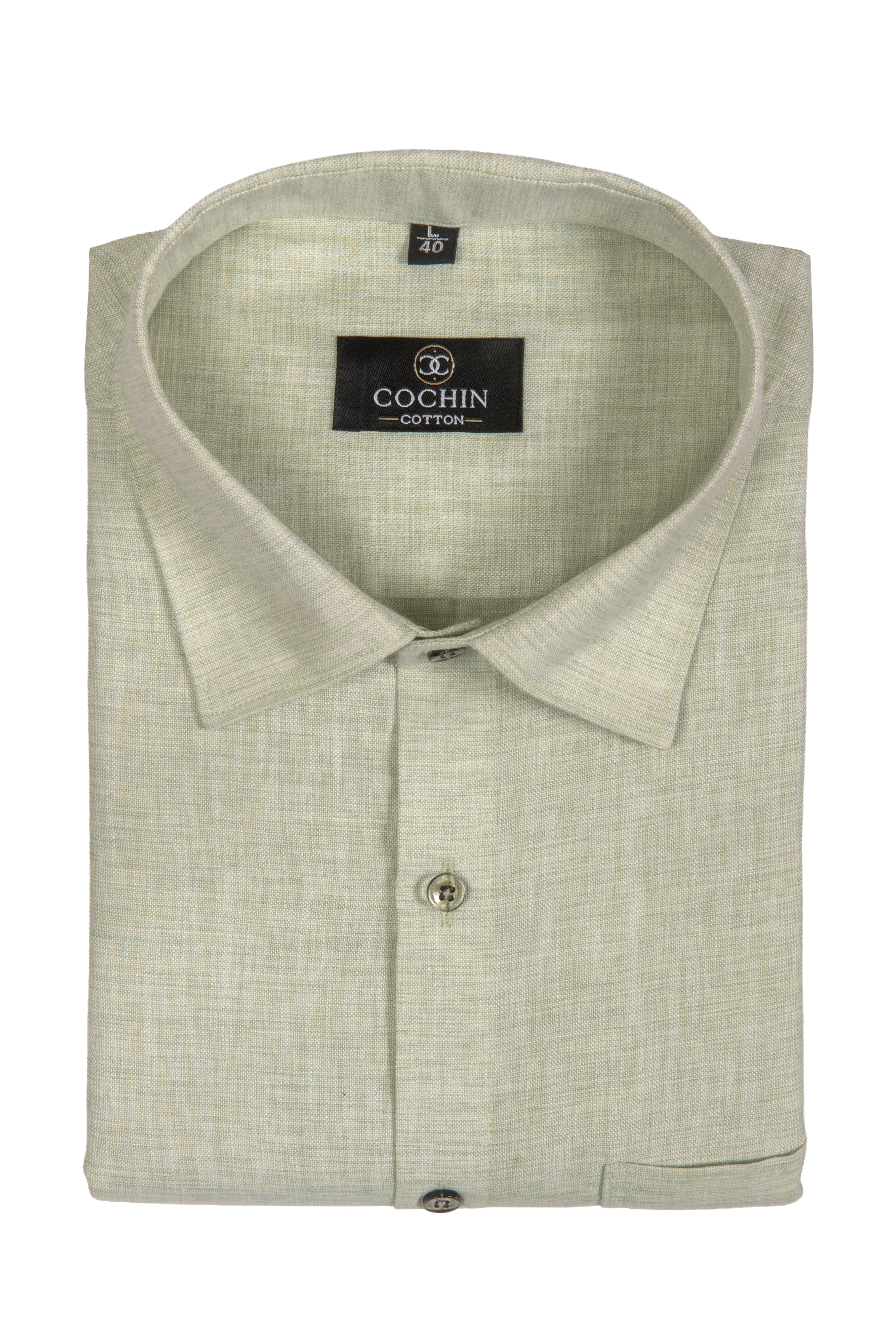 A folded light sage green linen shirt with a textured weave, featuring a pointed collar, silver-tone buttons, and a black Cochin Cotton brand label.