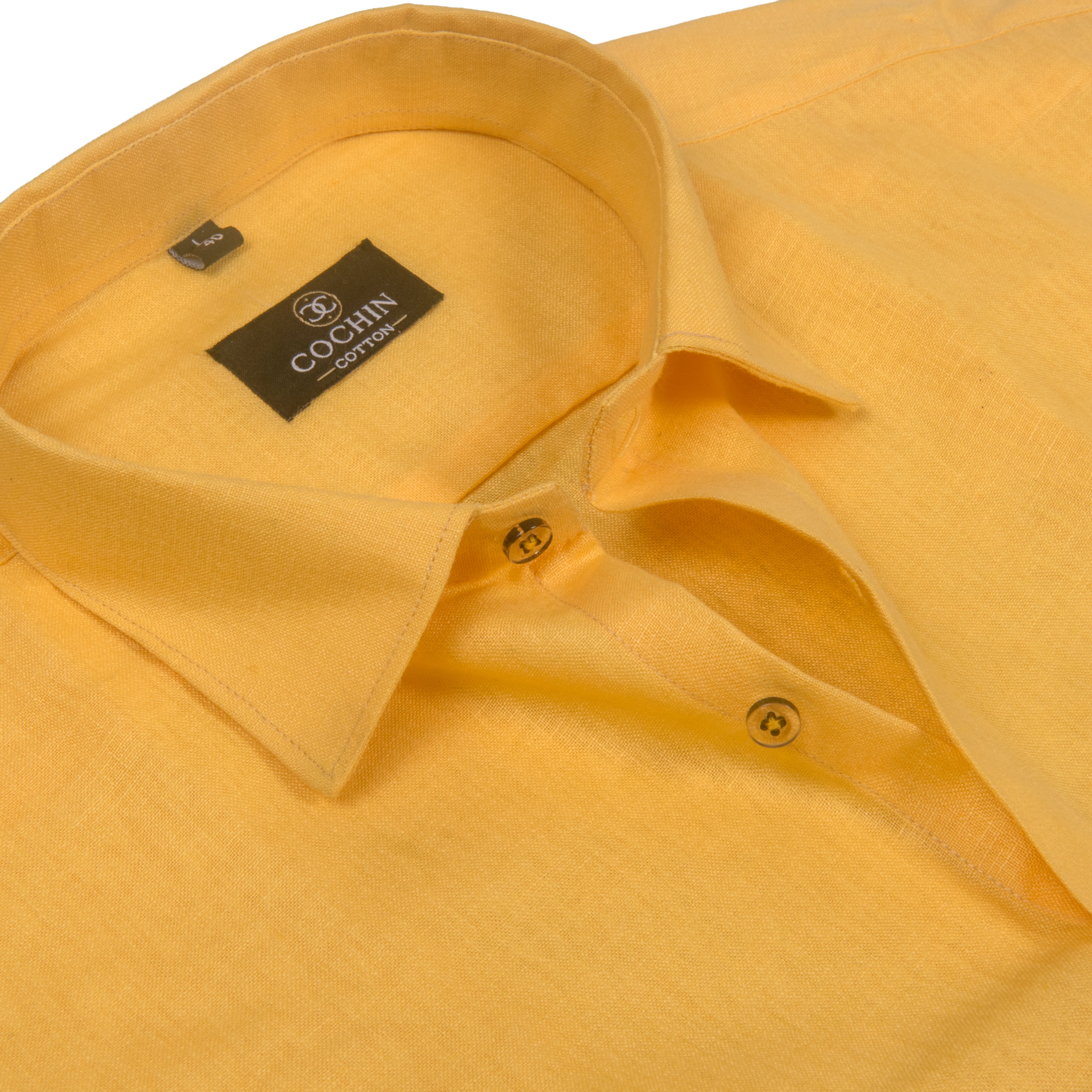 A close-up of a yellow linen shirt collar with a black brand label reading COCHIN CLOTHING.