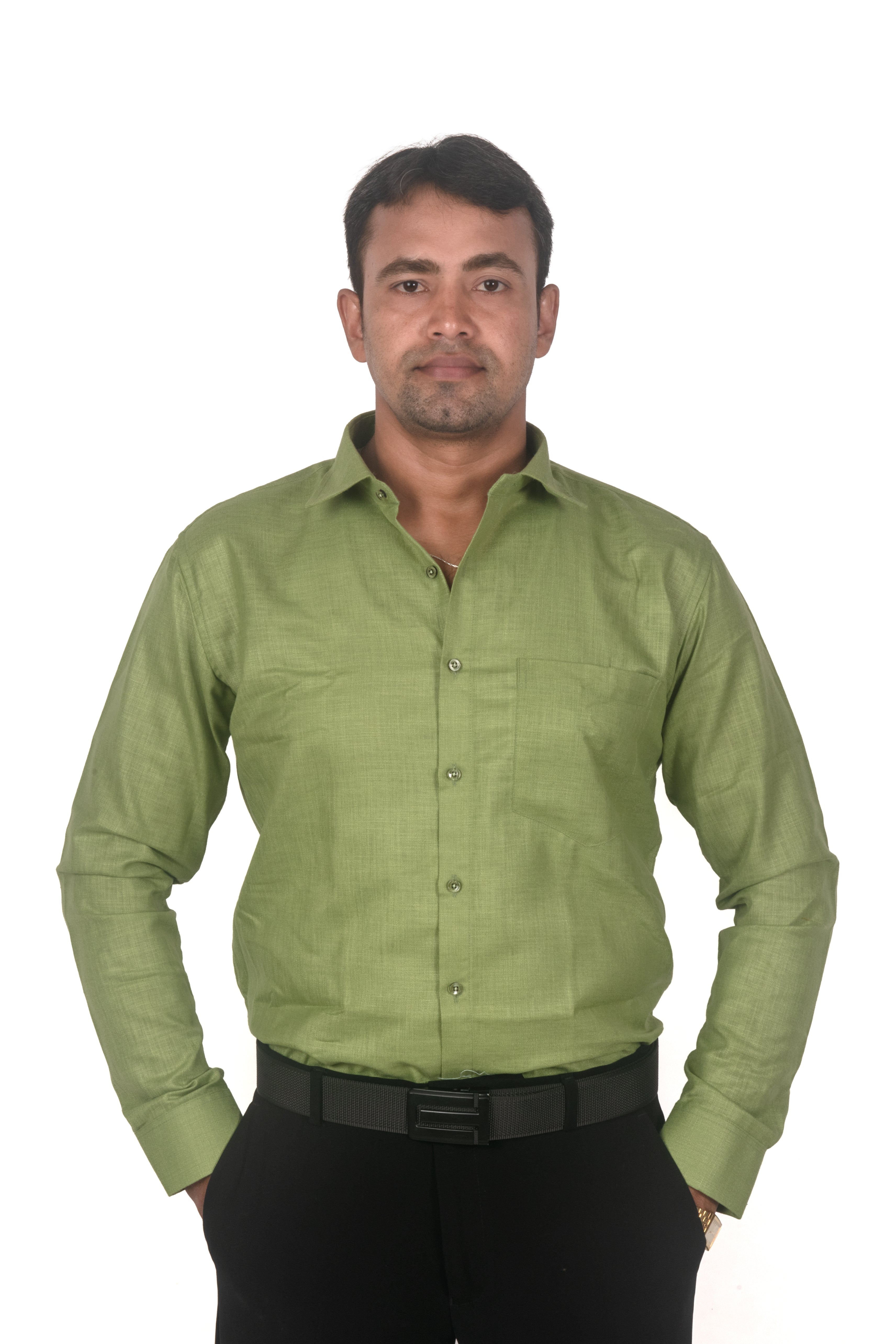 A man wearing a light olive green long-sleeve button-down shirt with black trousers and a black belt, standing against a plain white background.