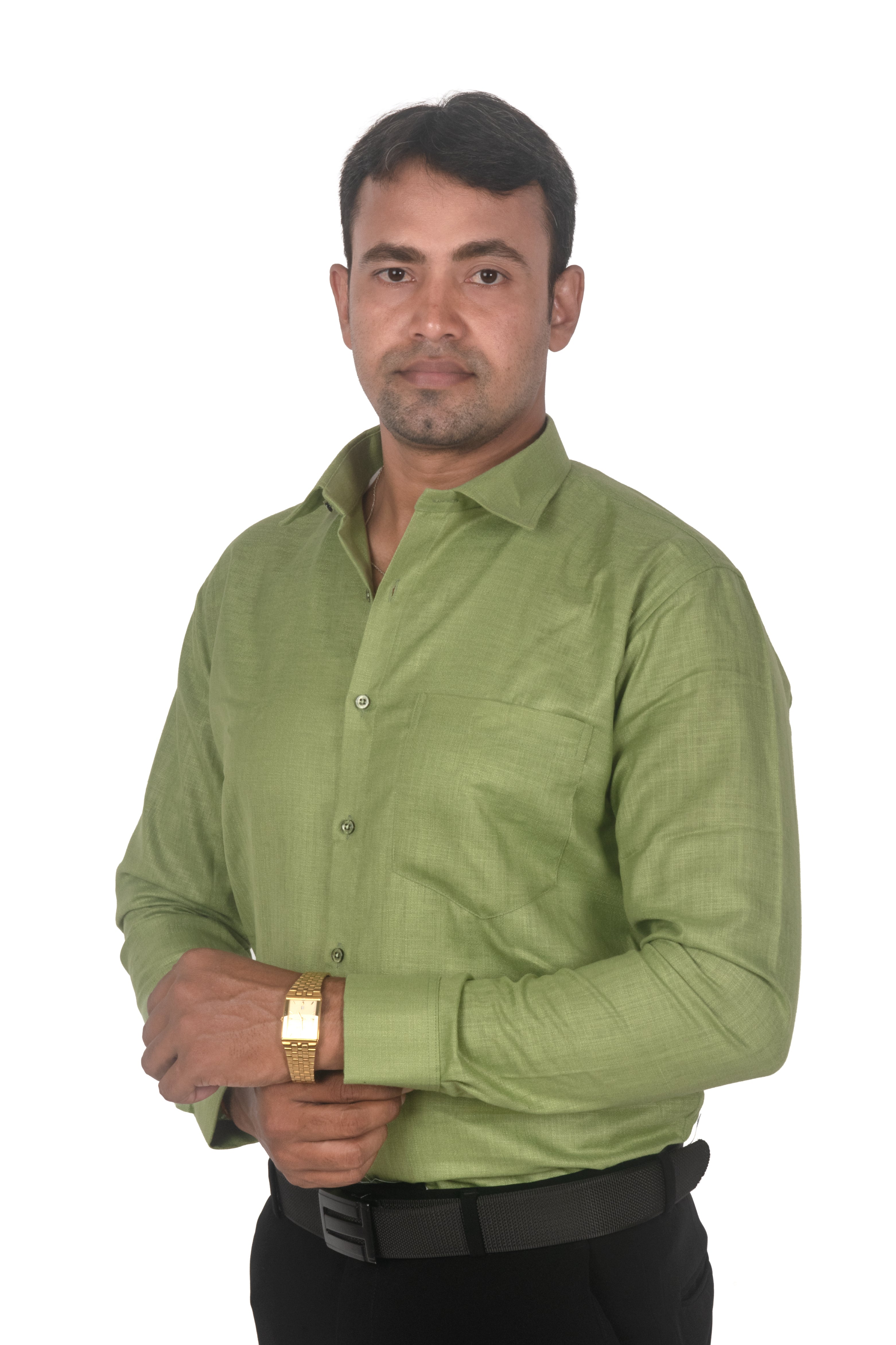 A man wearing a light olive green long-sleeve button-down shirt, black trousers, and a black belt, standing against a plain white background.