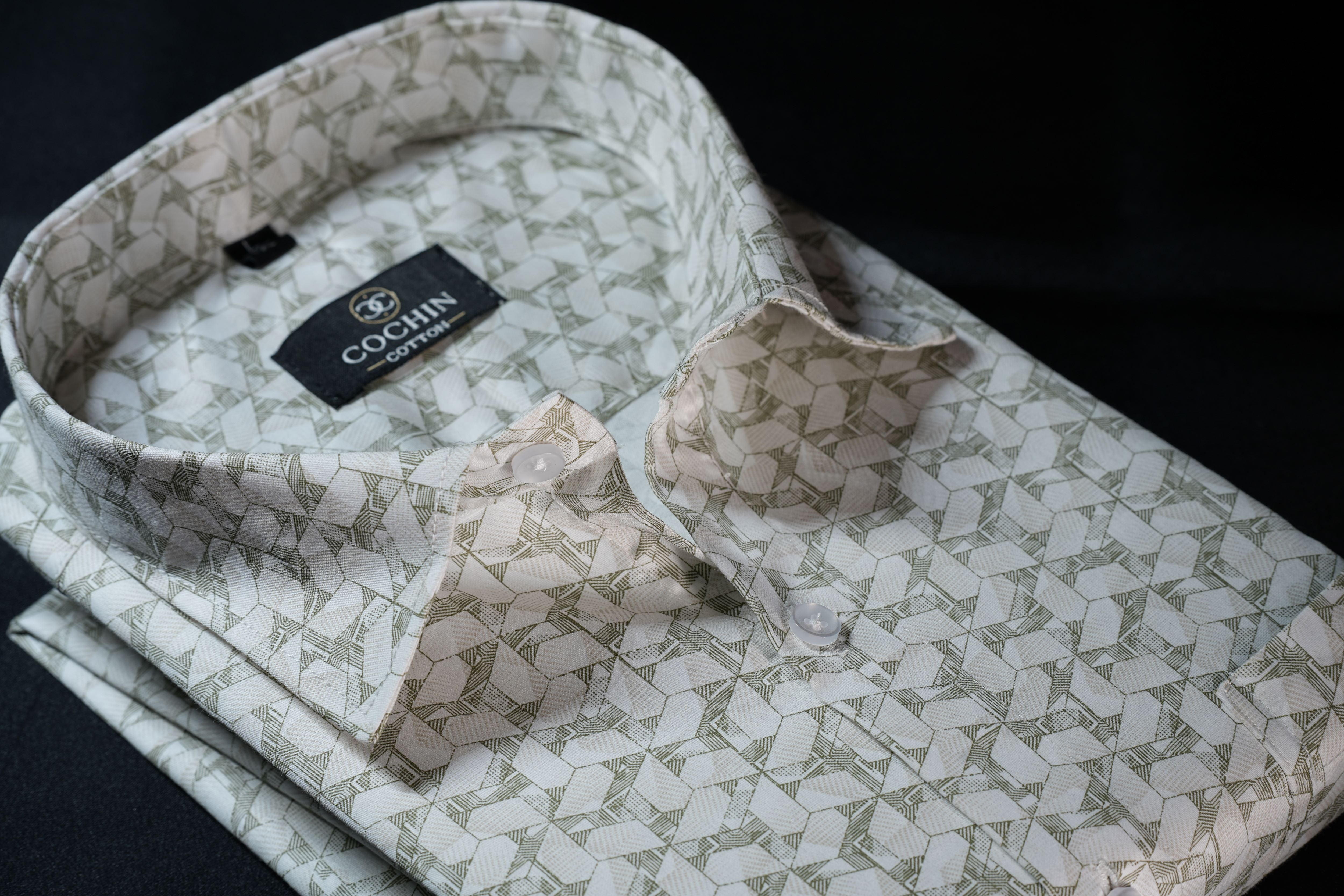 Folded patterned shirt with matching bow tie and cufflinks on a dark background