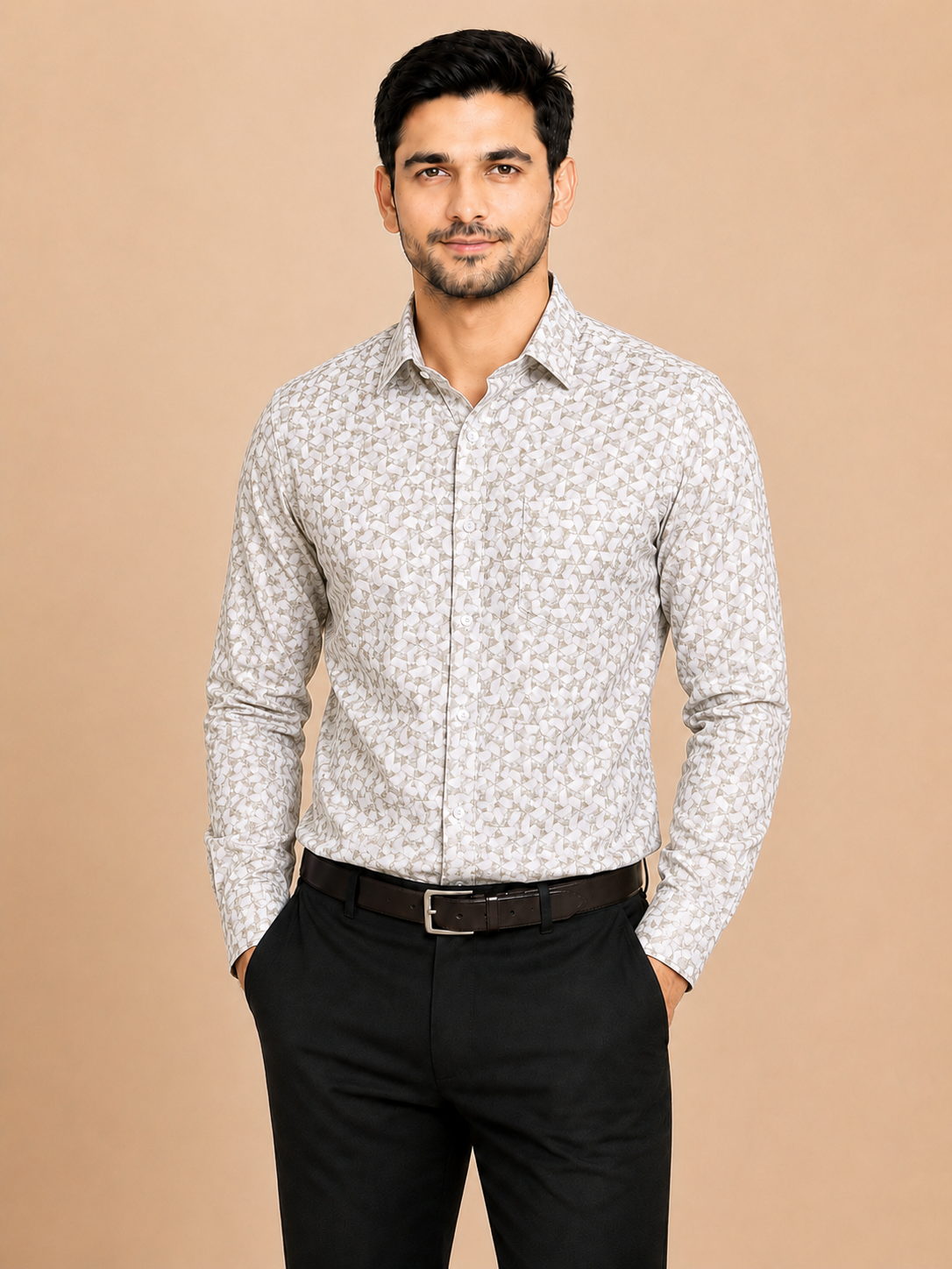 A man wearing a light beige and white patterned long-sleeve button-down shirt with black trousers, standing against a solid beige background.
