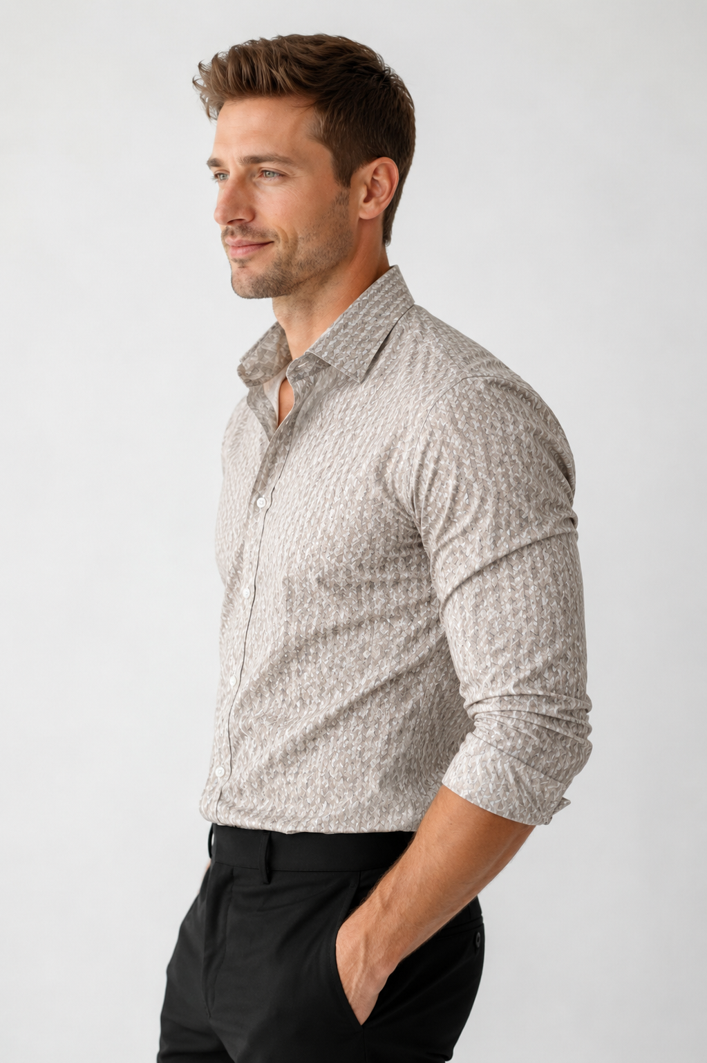 Man wearing a patterned shirt and black pants on a white background
