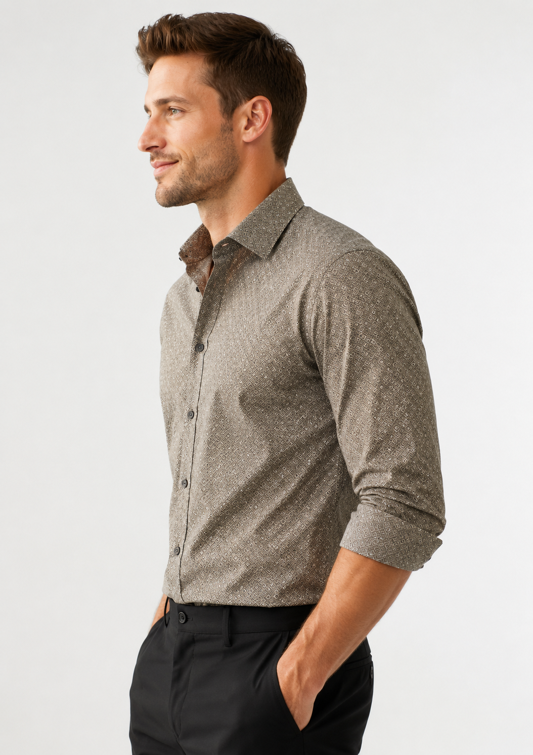 Man wearing a patterned shirt and black pants on a light gray background