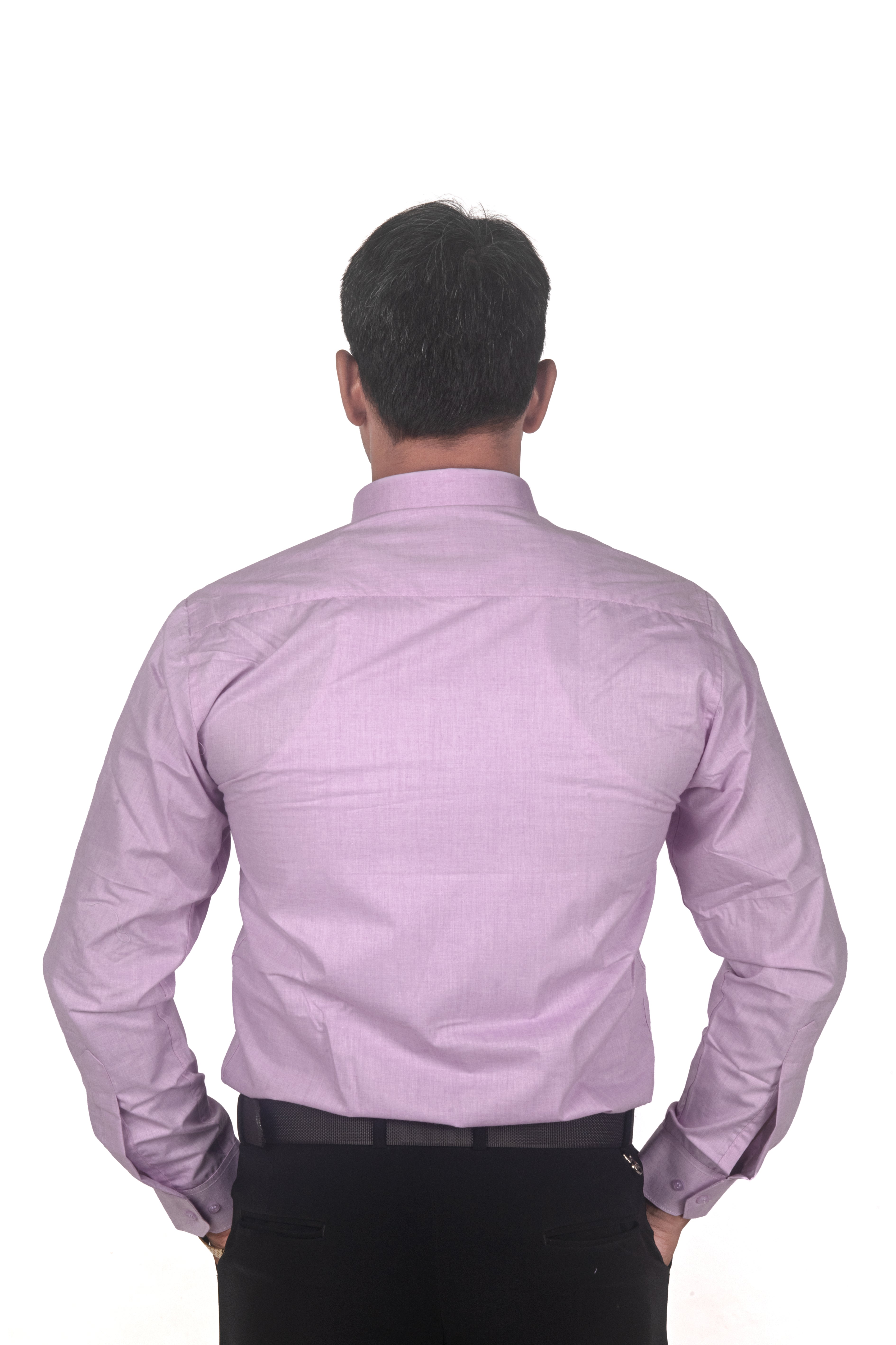 A man viewed from behind wearing a light purple long-sleeve button-down shirt and black trousers, standing against a plain white background.