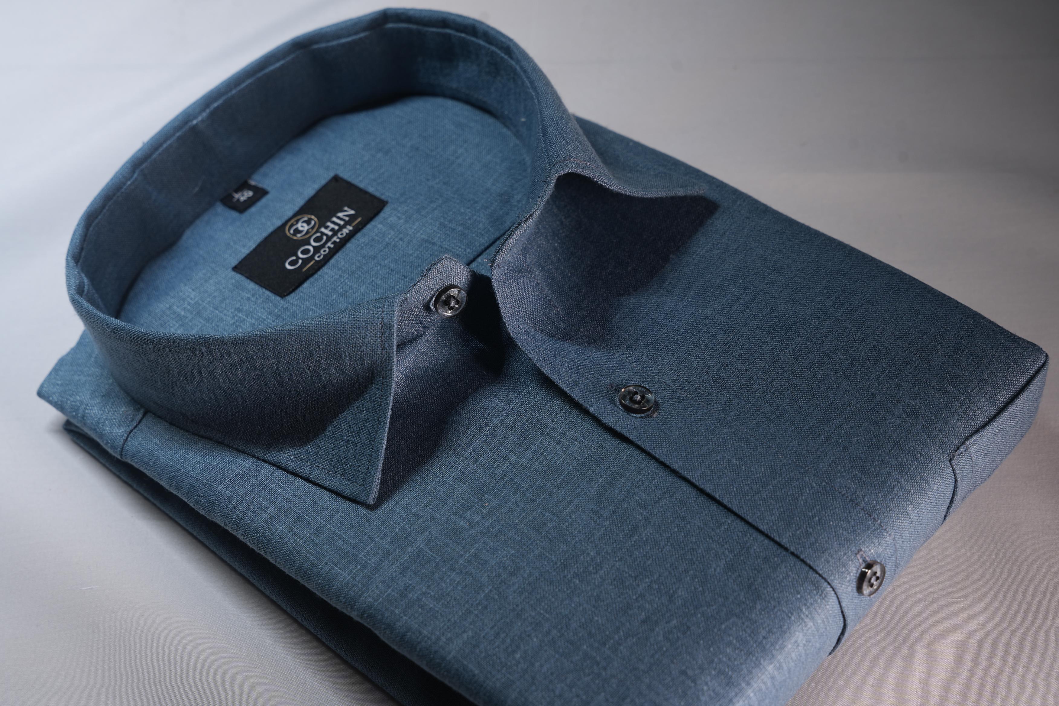 Blue shirt with a brand label on a light gray background