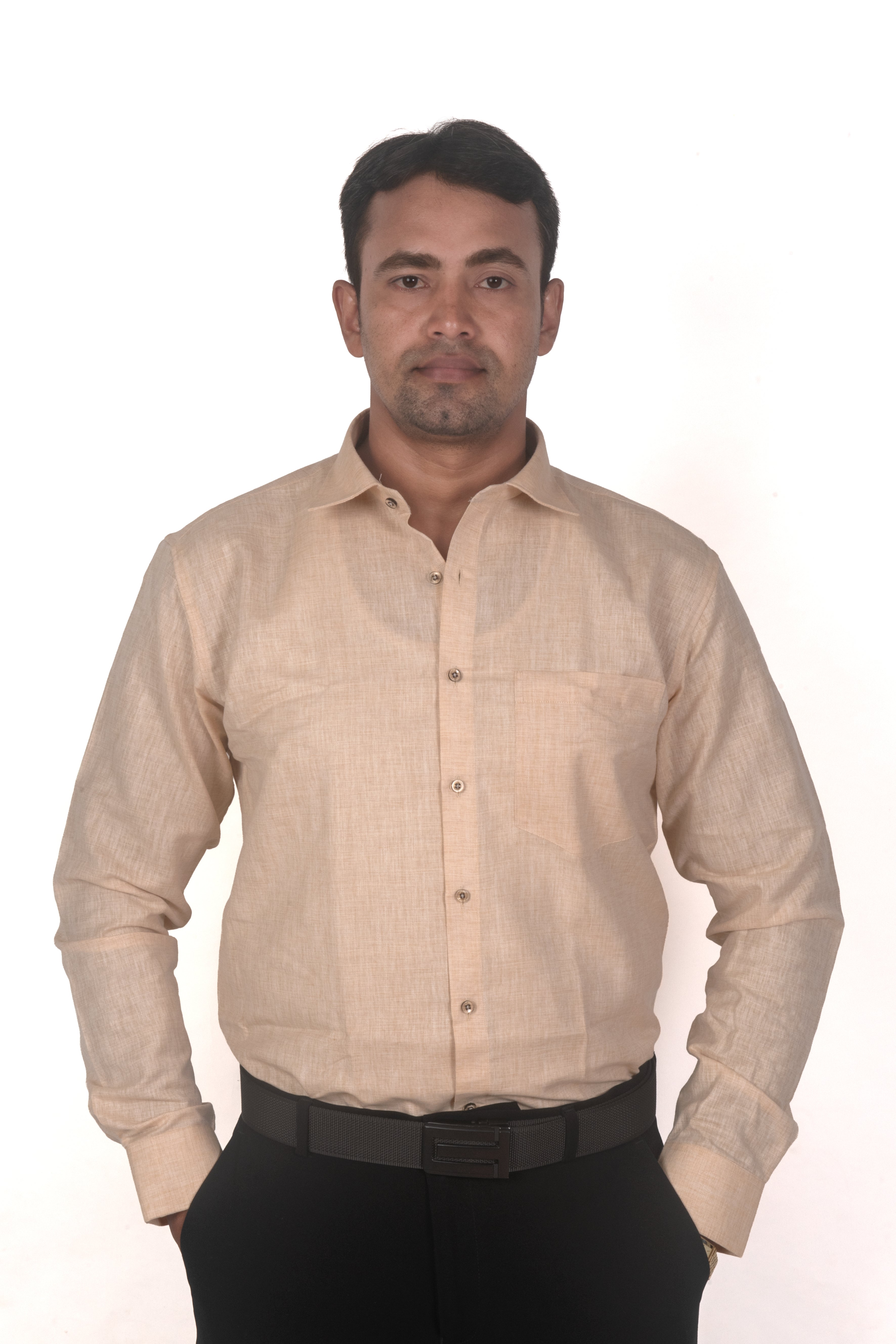 A man wearing a light beige linen long-sleeve button-down shirt and black trousers, standing against a plain white background.