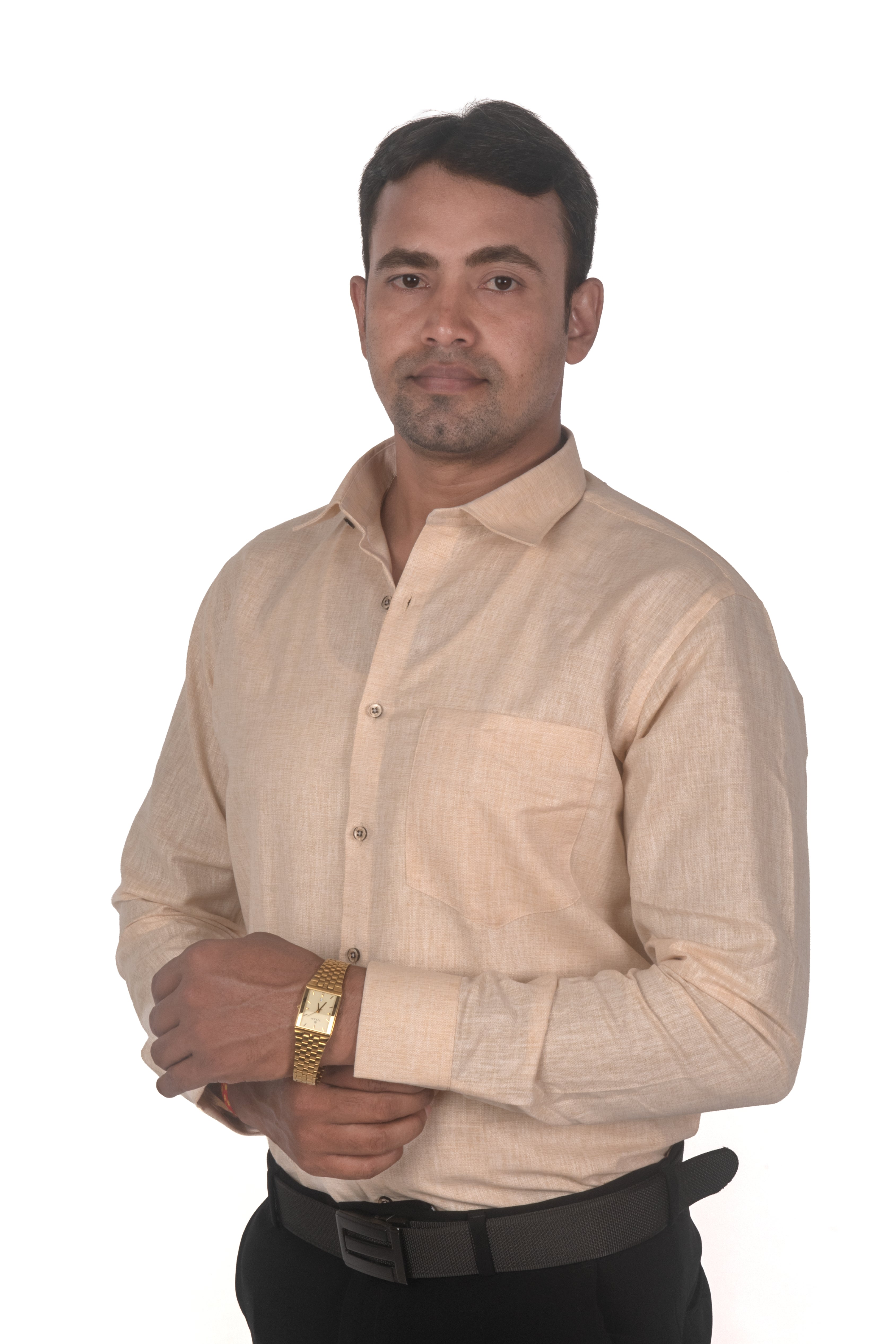 A man wearing a light beige linen button-down shirt and black trousers, standing against a solid white background.