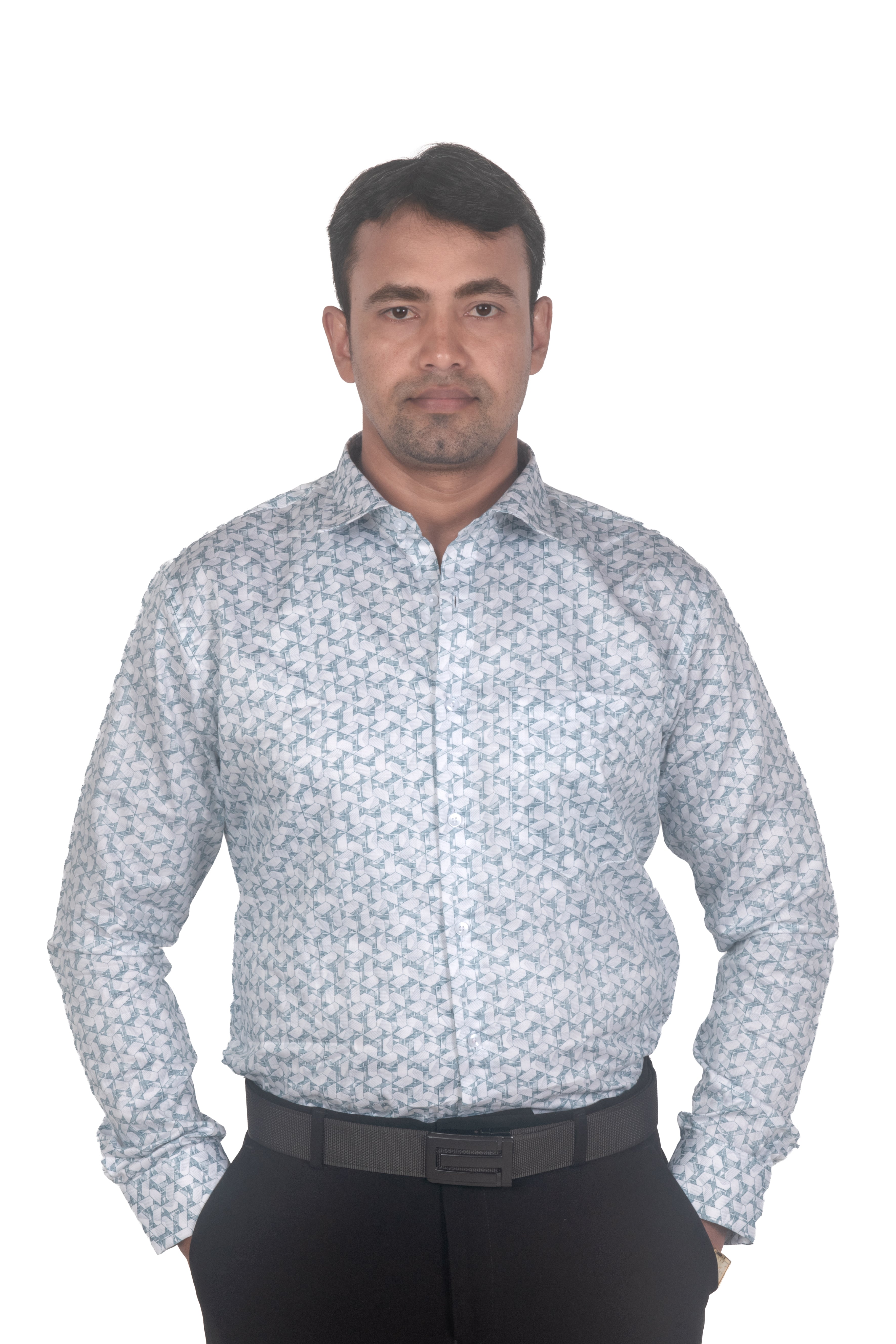 A man wearing a light gray and white patterned long-sleeve button-down shirt with black trousers, standing against a plain white background.
