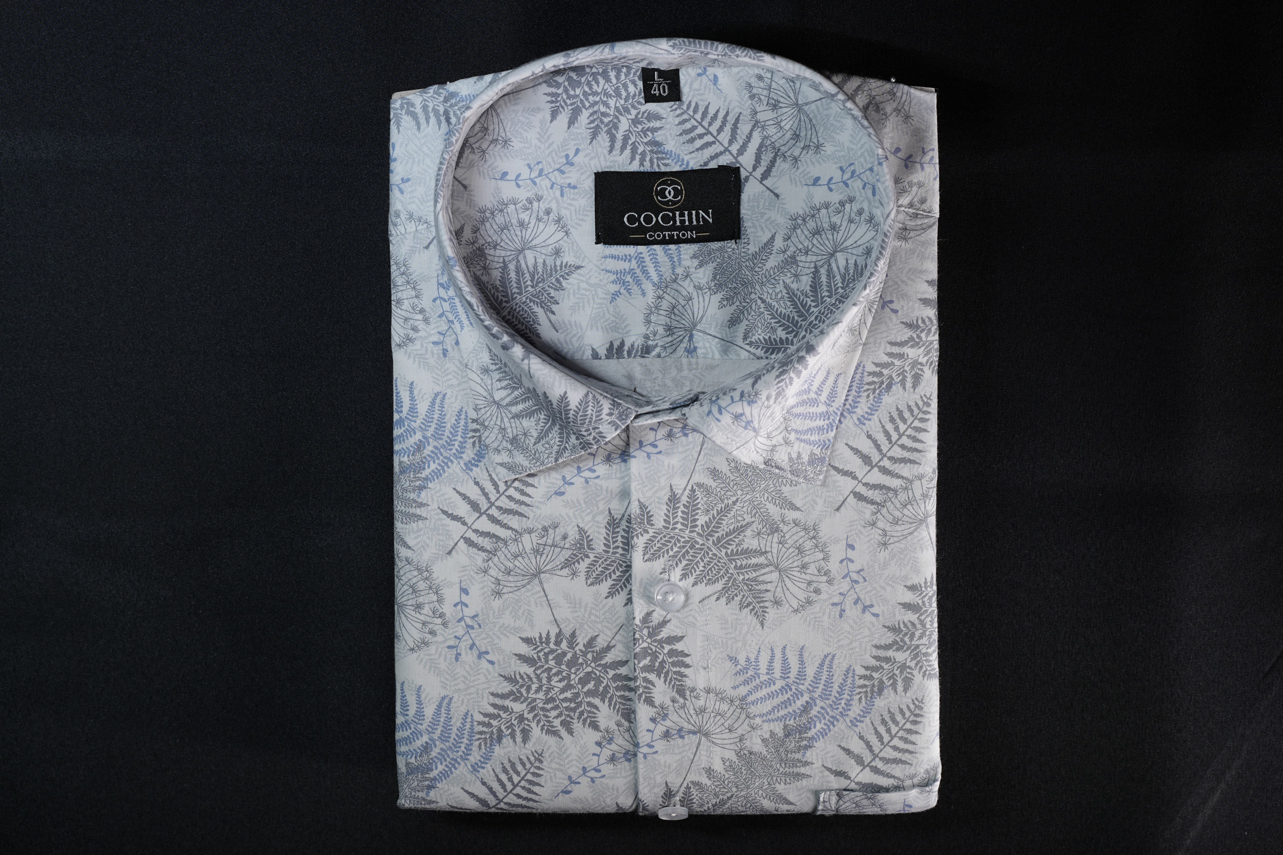 Folded shirt with fern pattern and 'Cochin' label on a black background