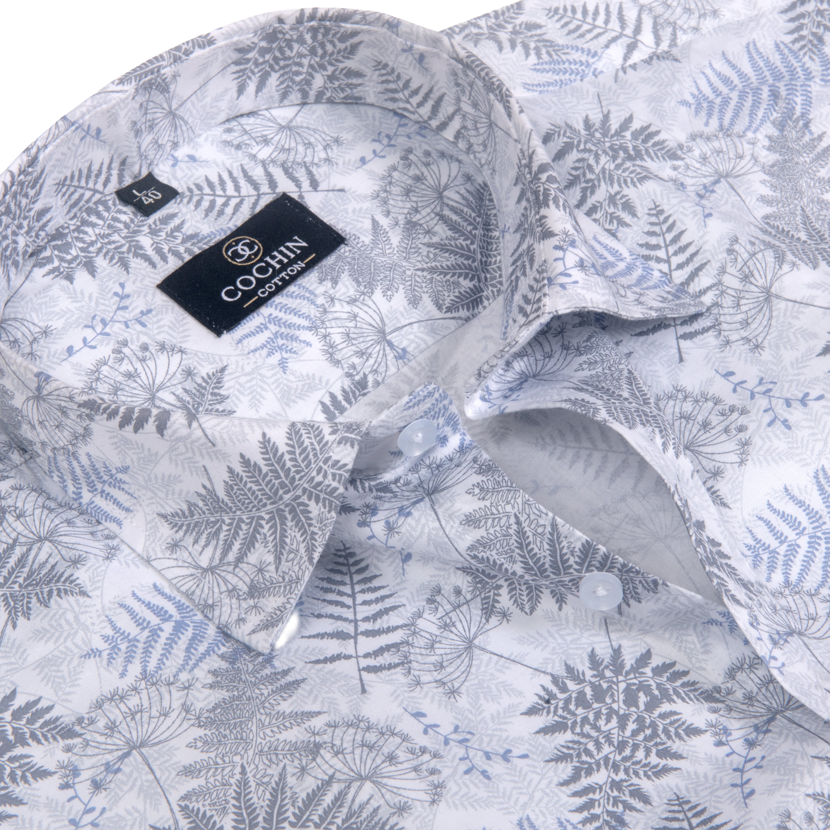 A close-up of a Cochin Couture button-down shirt featuring a white base with a detailed gray and light blue fern and botanical leaf pattern.