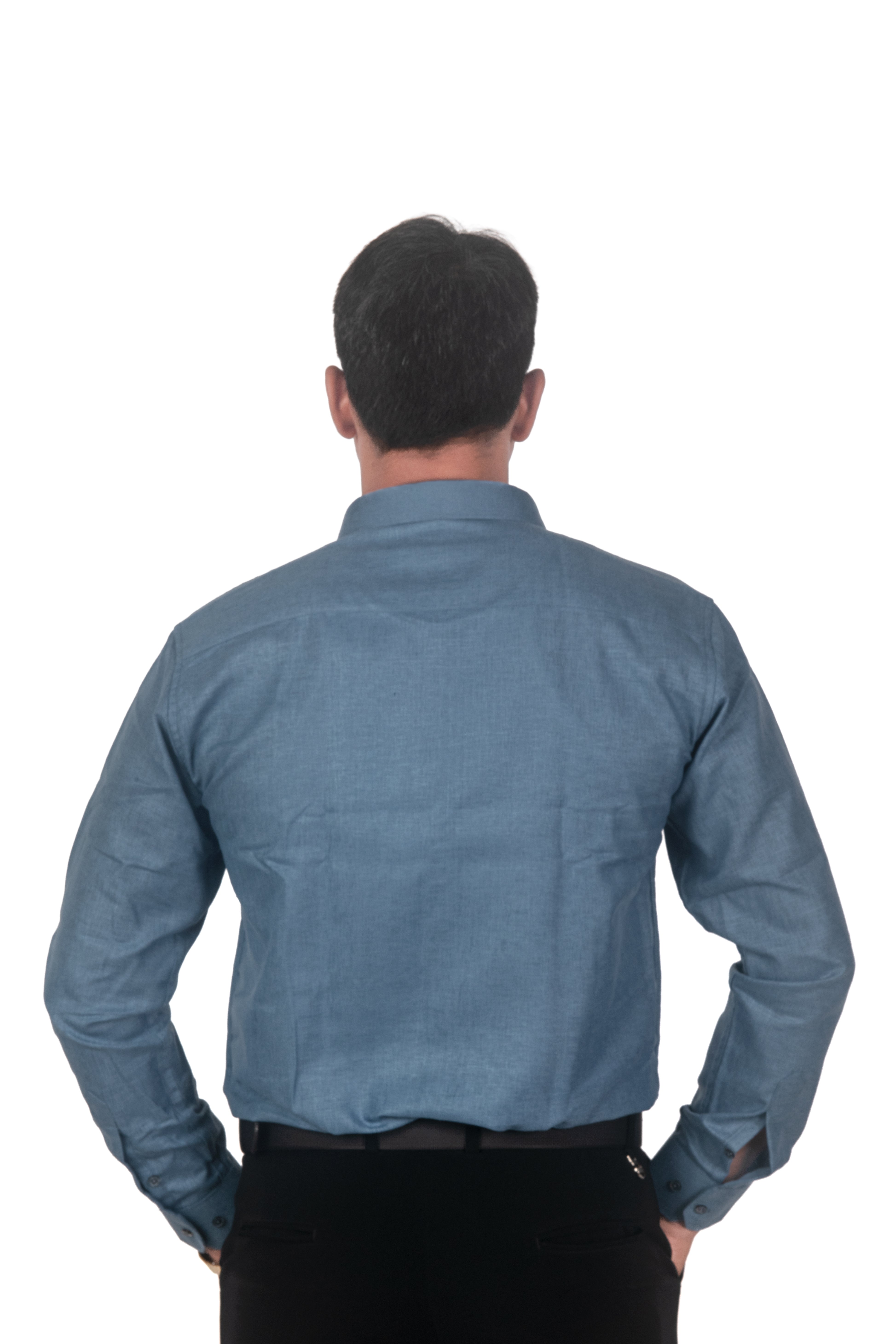 A man viewed from the back wearing a slate blue long-sleeve button-down shirt and black trousers, isolated on a white background.