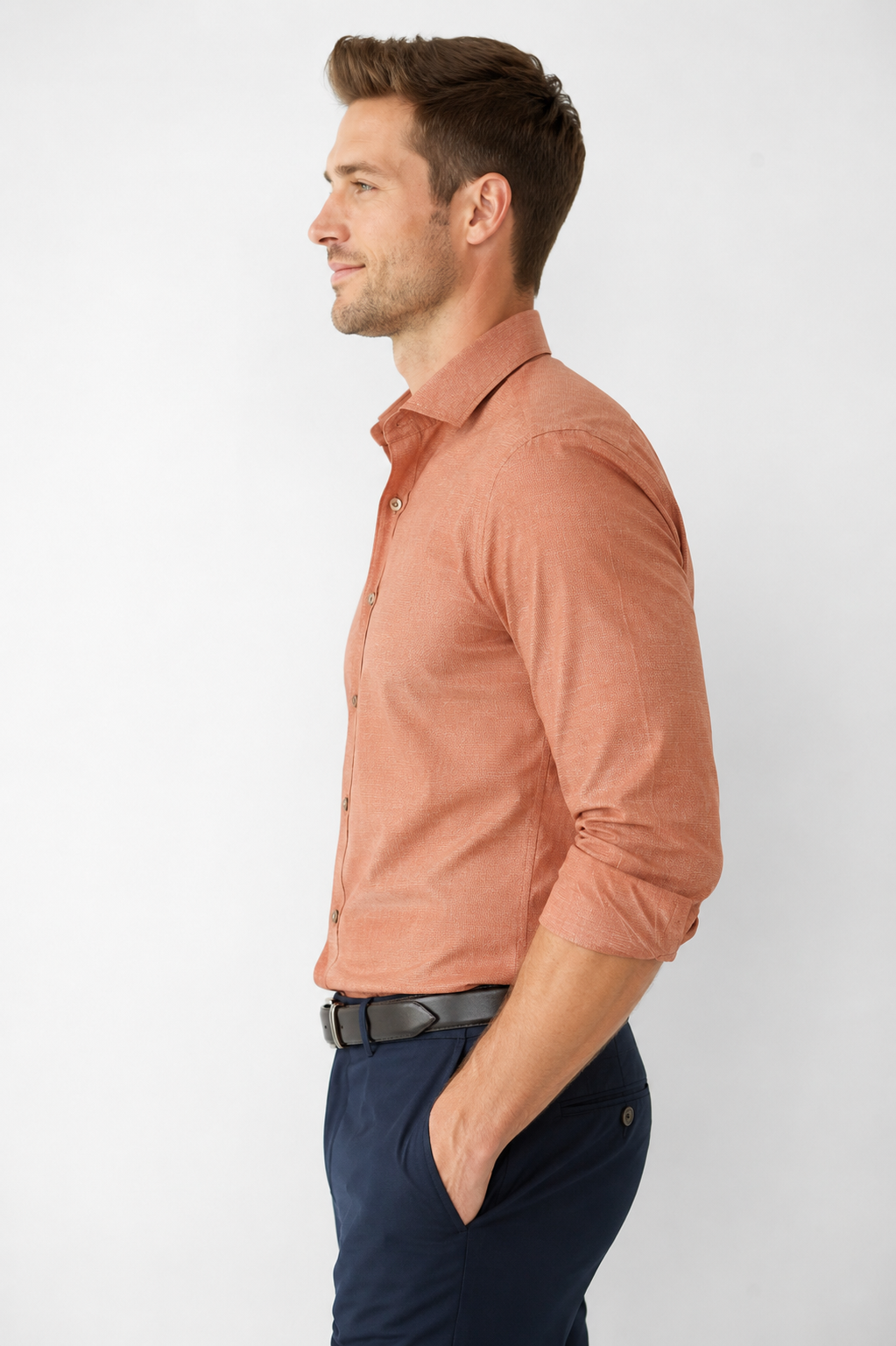 Man wearing a brown shirt and dark pants on a white background