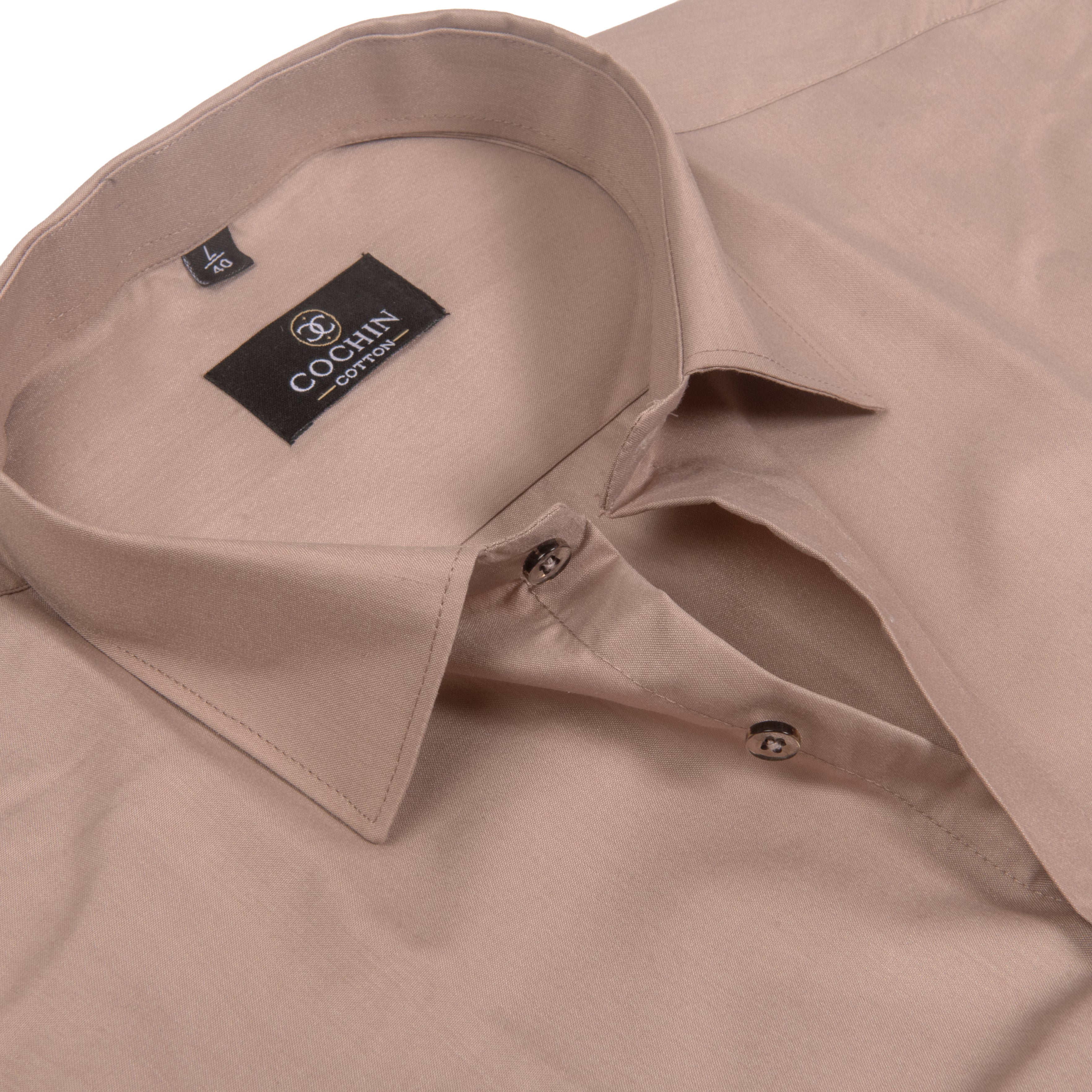 A close-up of a light beige long-sleeve dress shirt by Coach, showing the collar, inner neck label, and buttoned placket against a white background.
