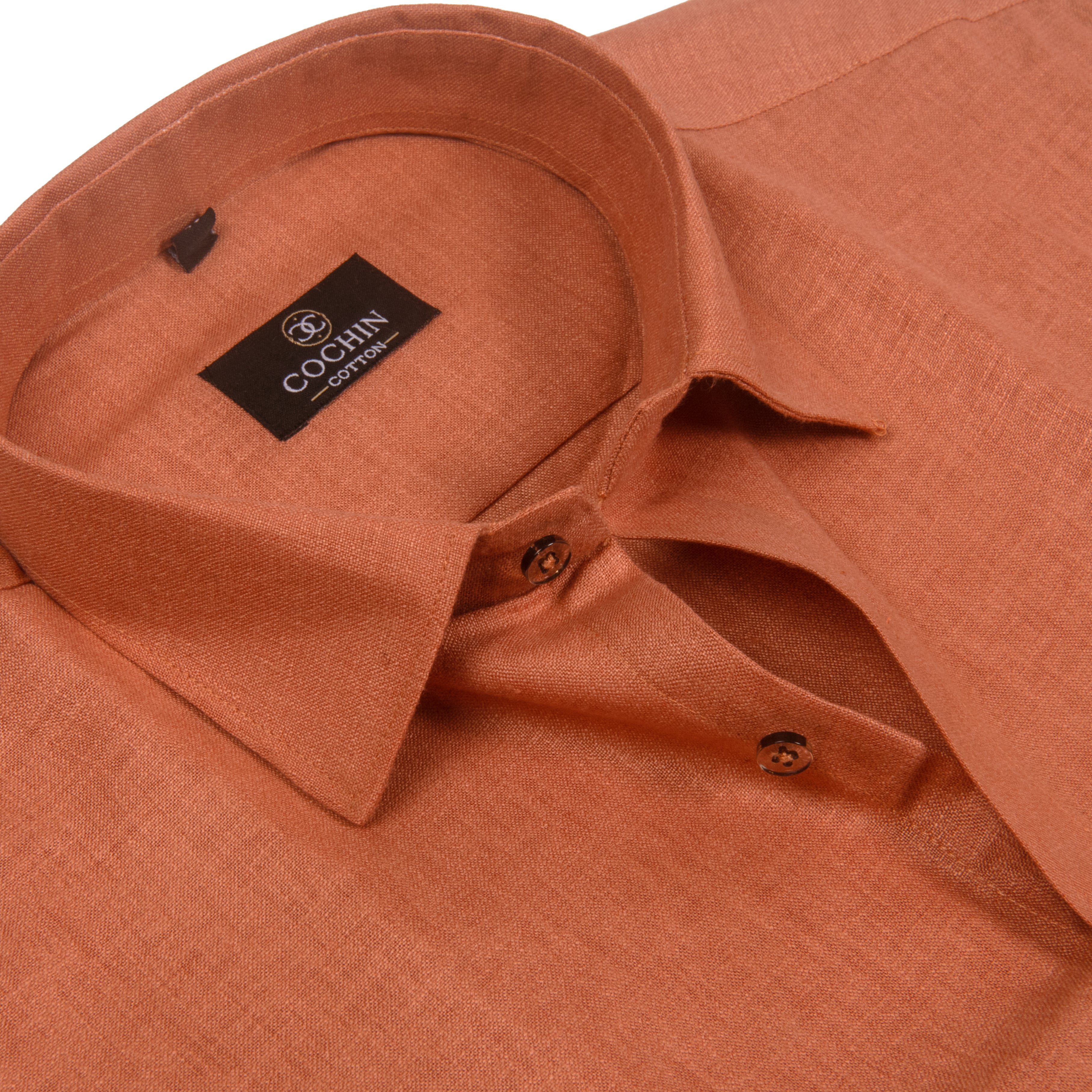 Close-up of a textured orange linen shirt collar with a black COCHIN COLLECTION brand label.