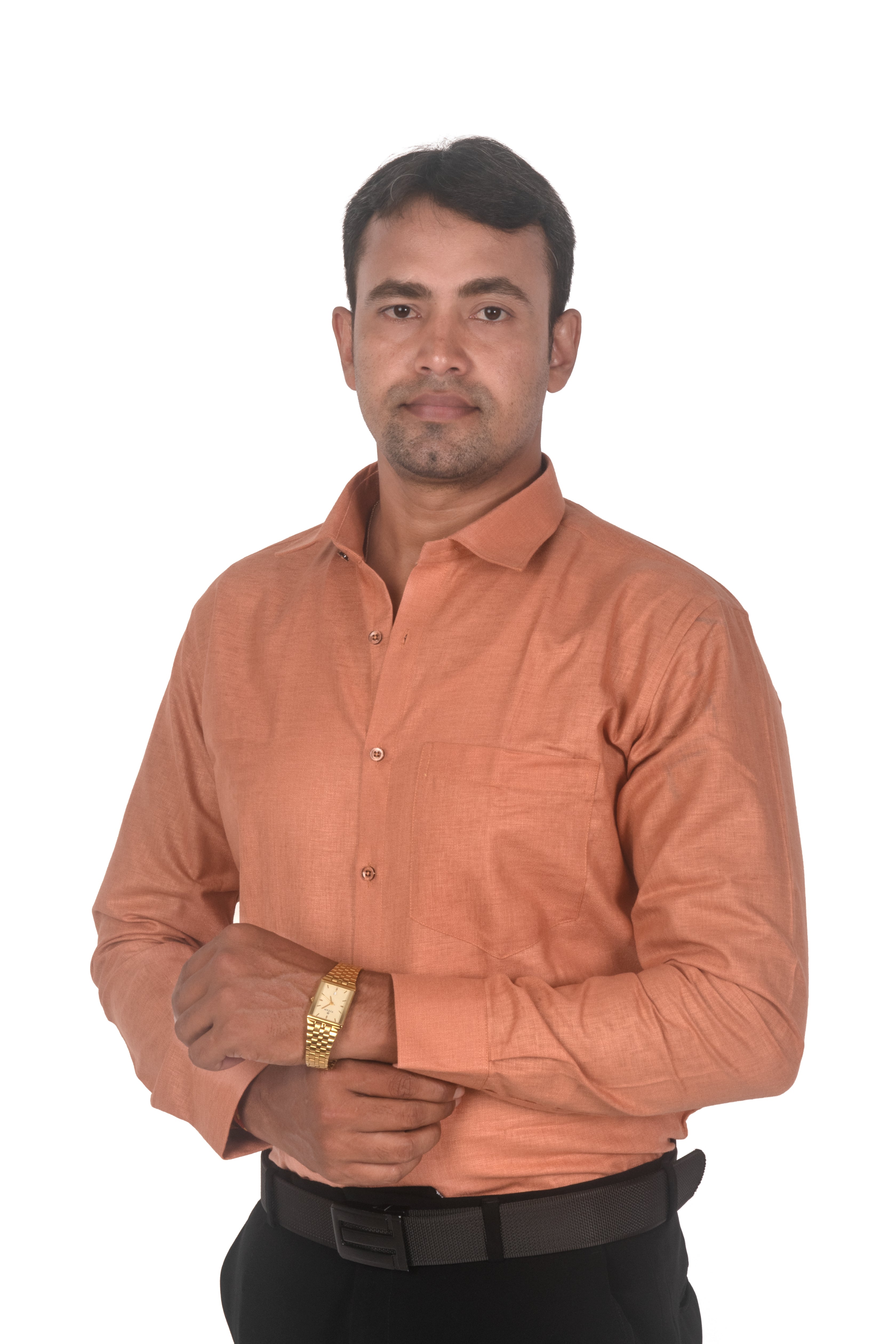 A man wearing a long-sleeve button-up shirt in a muted terracotta or burnt orange color, paired with black trousers and a gold watch, photographed against a plain white background.