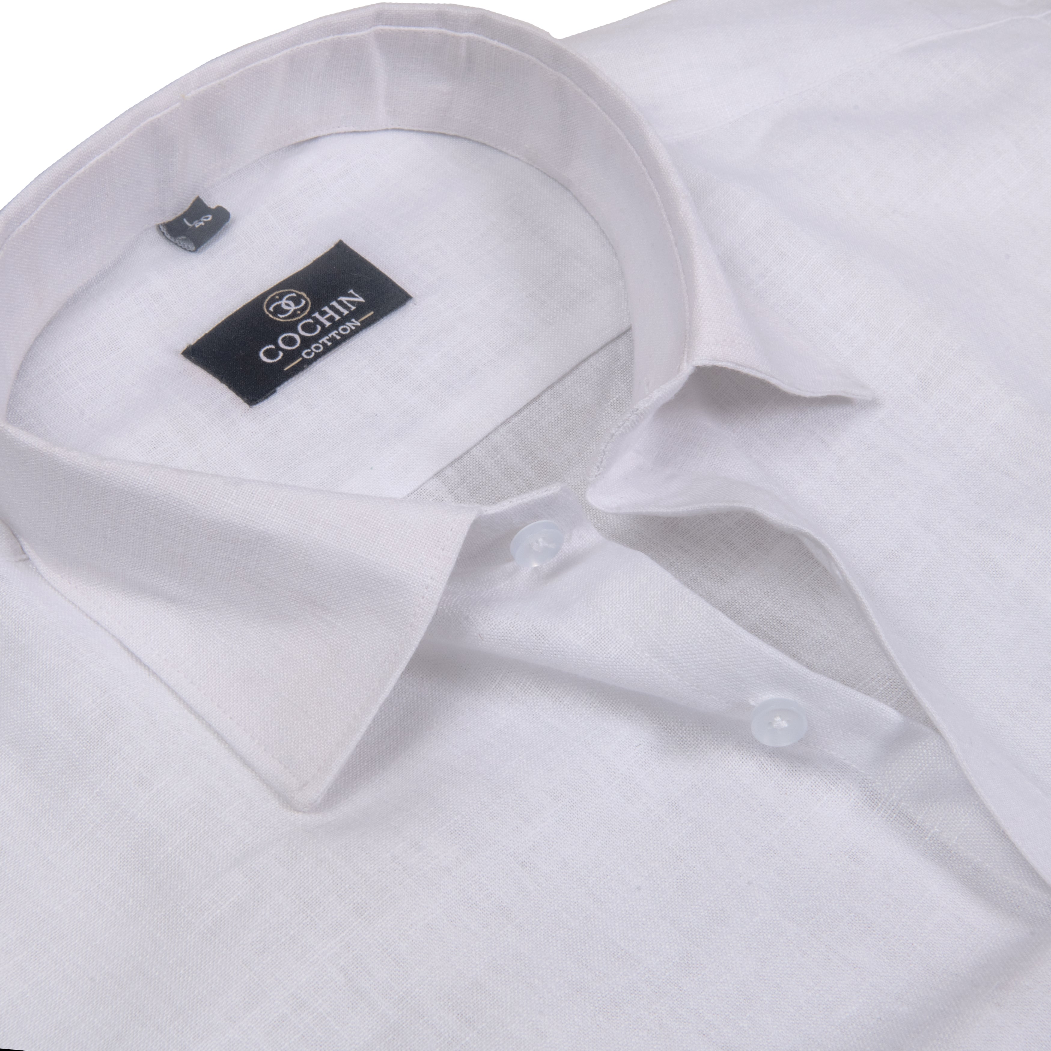 Close-up of a white long-sleeve button-down shirt with a pointed collar and a visible black Coccin Cotton brand label inside the collar.