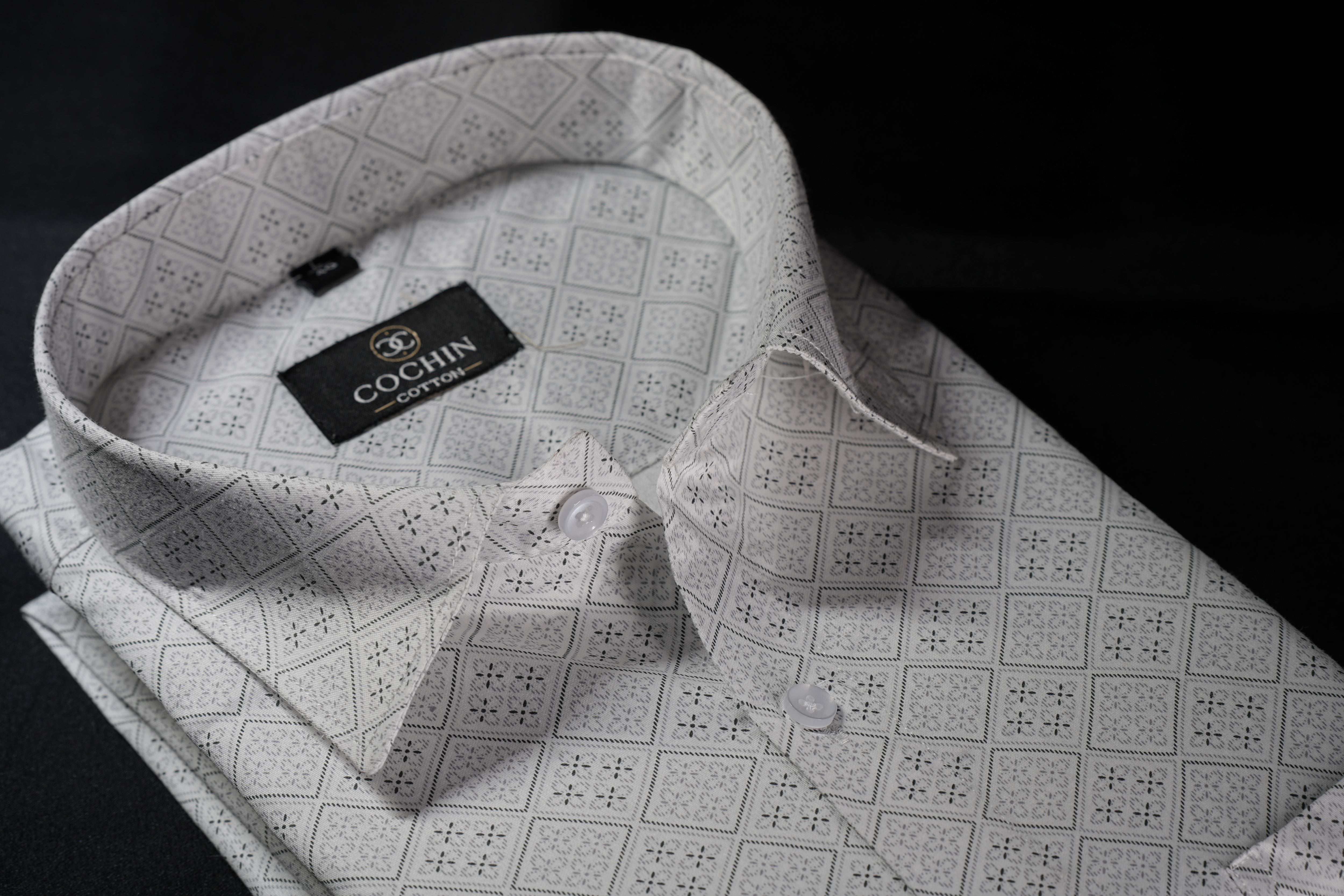 Folded gray patterned shirt with 'Cochin' label on a black background