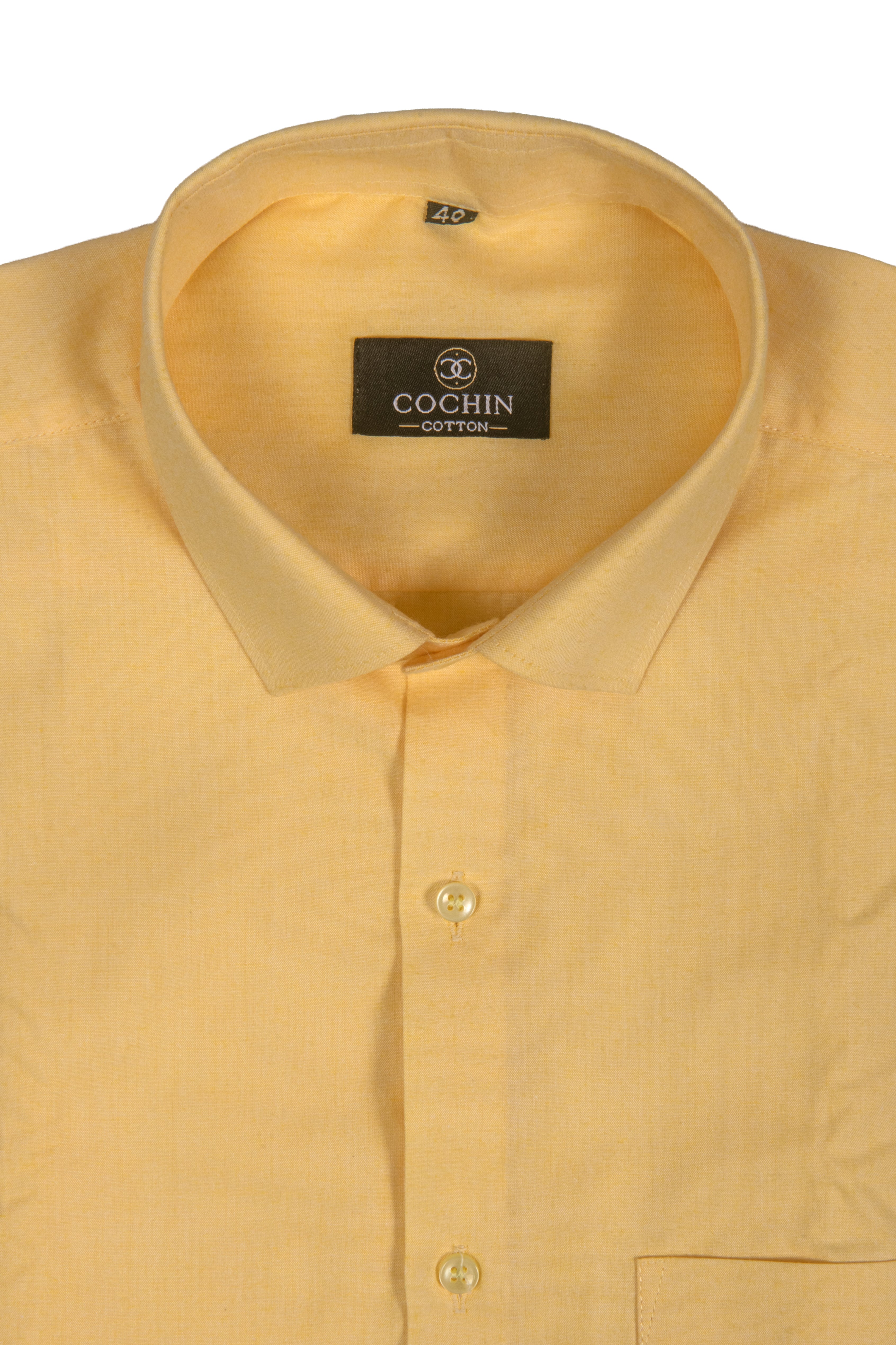 A close-up of a light yellow Cochin cotton dress shirt showing the collar, brand label, and front button placket on a white background.