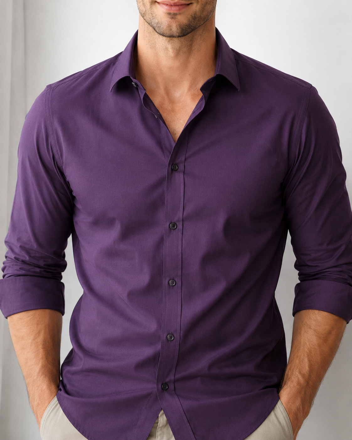 Man wearing a purple button-up shirt against a plain background