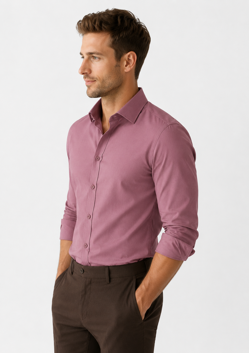 Man wearing a mauve button-up shirt and dark pants on a white background