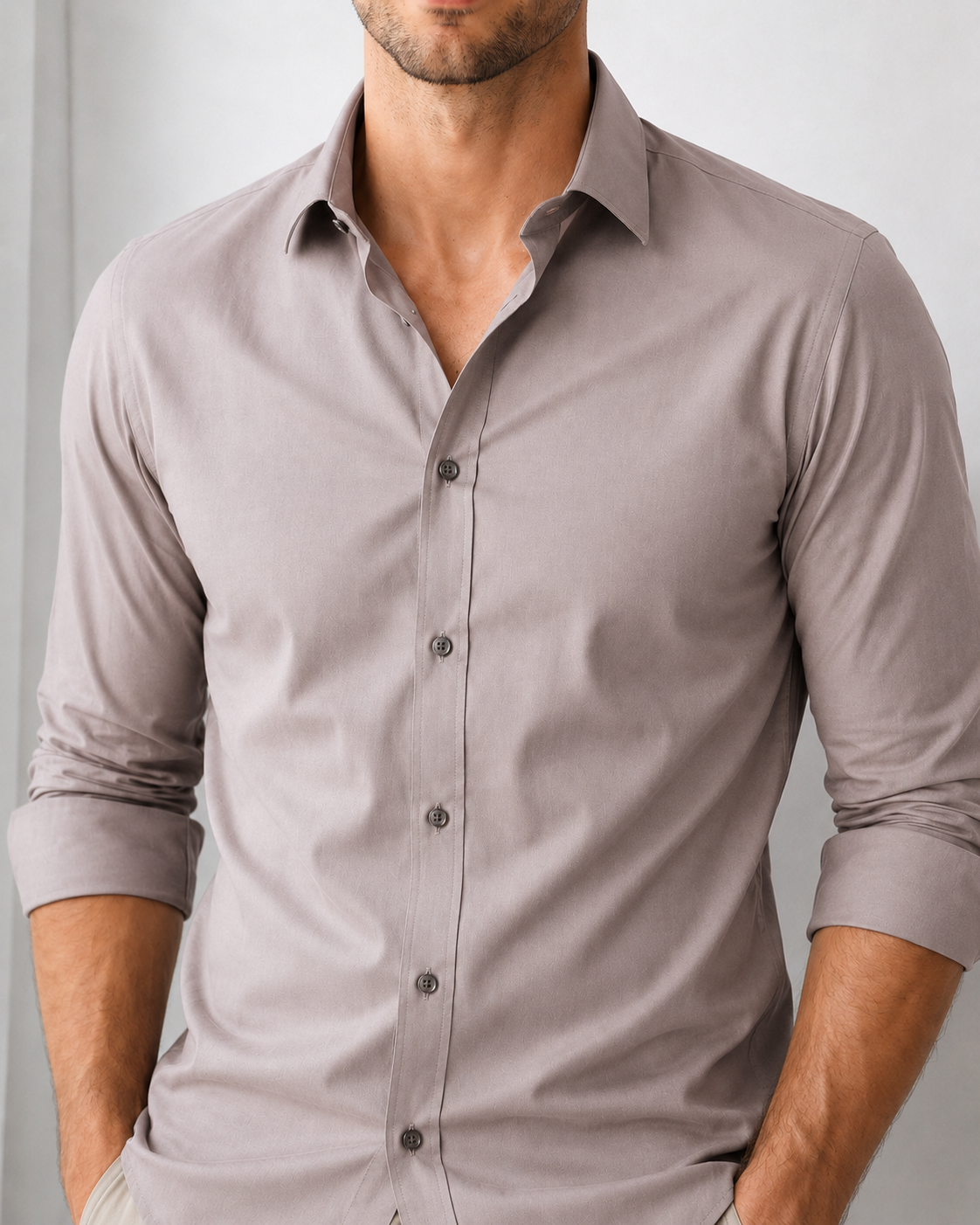 Man wearing a gray button-up shirt against a plain background