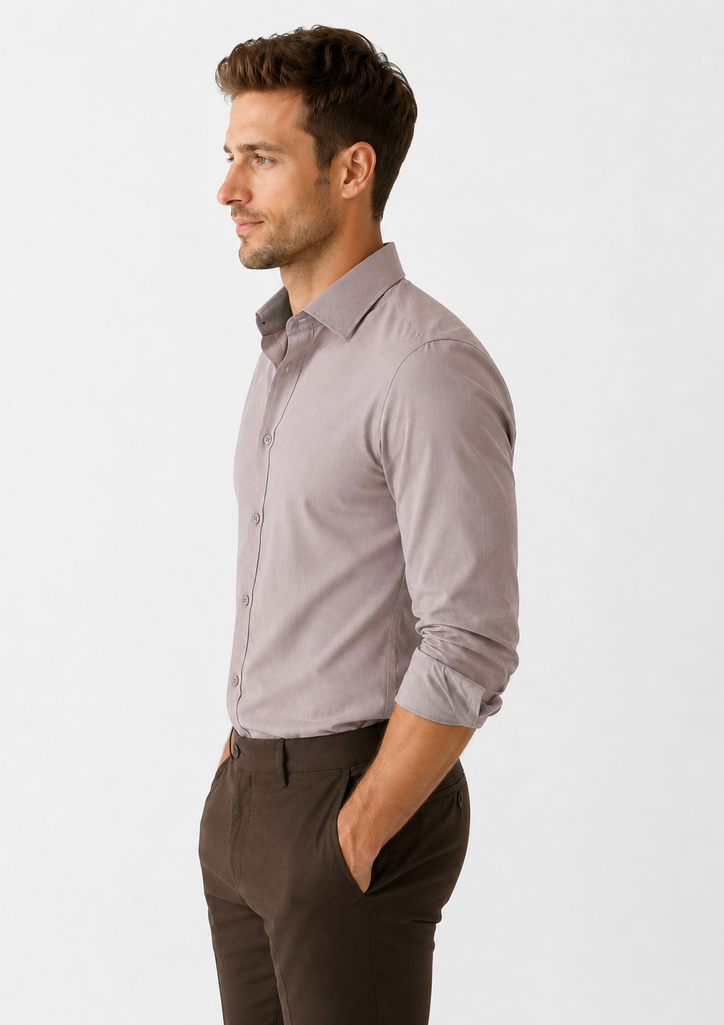 Man wearing a light gray dress shirt and dark brown pants on a white background